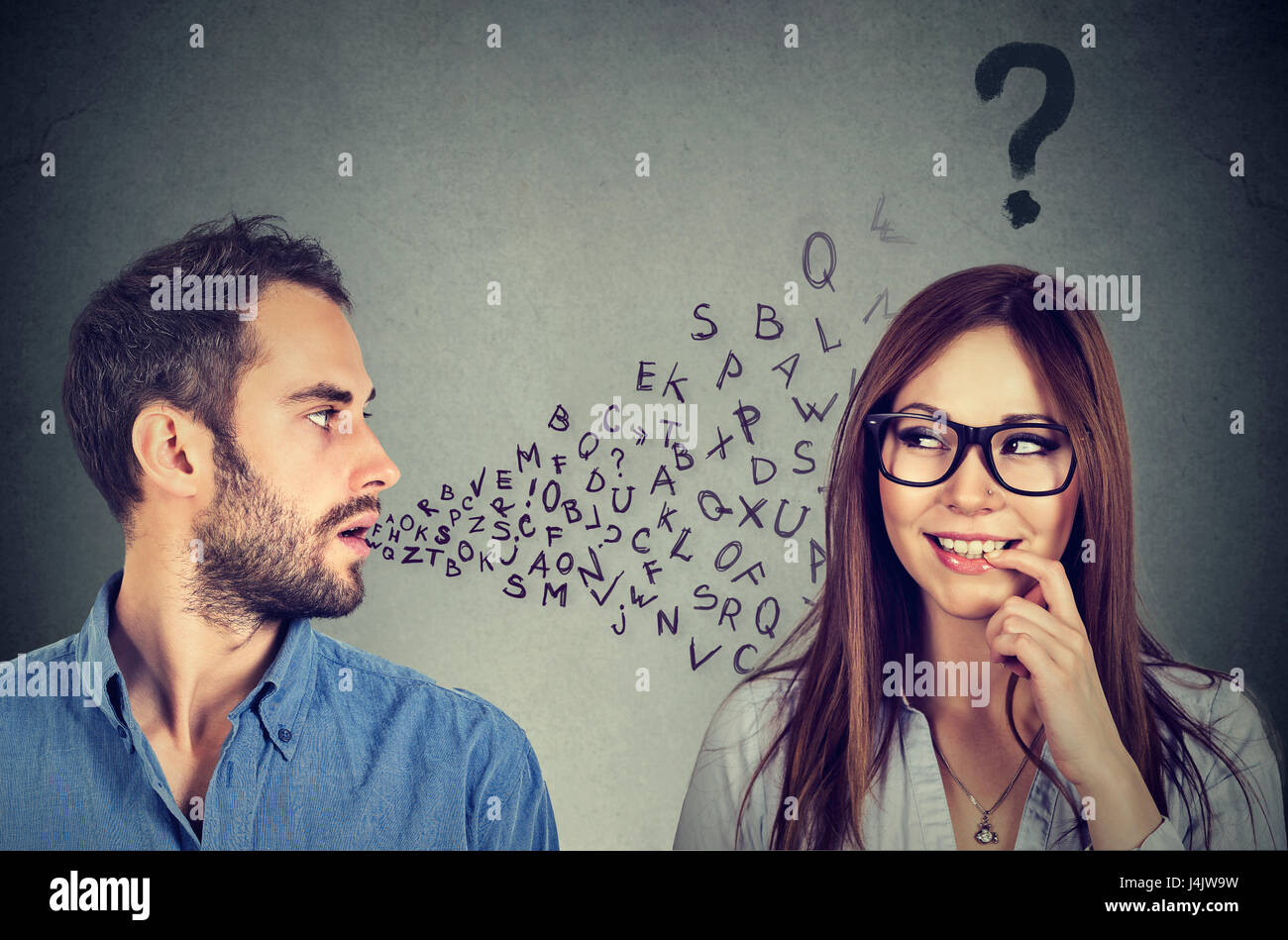 Language barrier concept. Handsome man talking to an attractive young woman with question mark Stock Photo