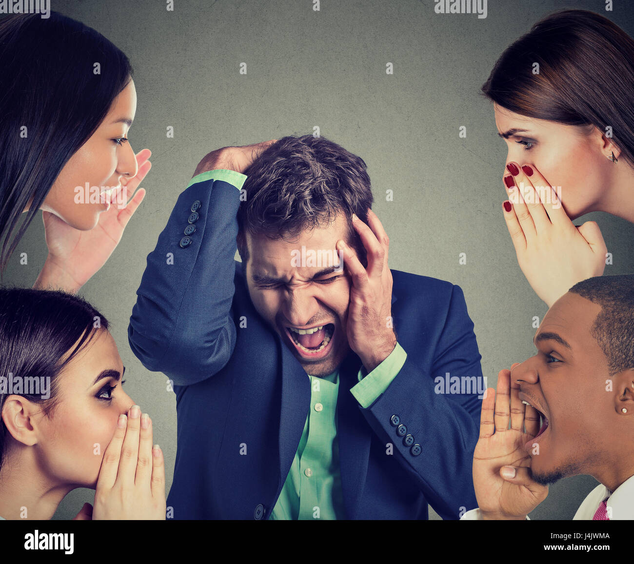 Group of people whispering to a desperate stressed business man Stock Photo