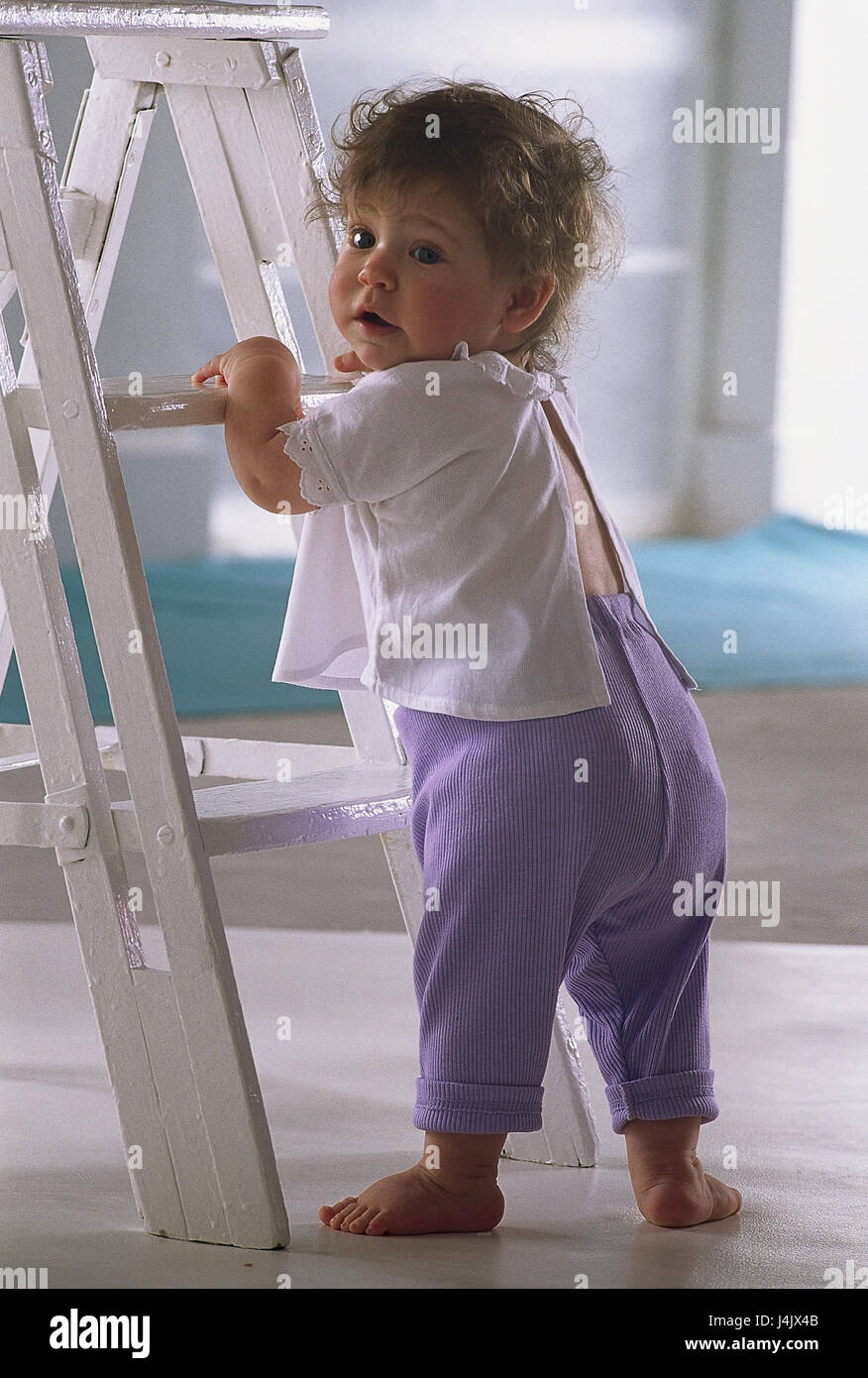 Baby, conductor, learn stick, walking attempt, back view inside, at home, child, infant, barefoot, to go, stand, try, try out, stepladder, learning process, development, development phase, carefully, curiously, look around Stock Photo