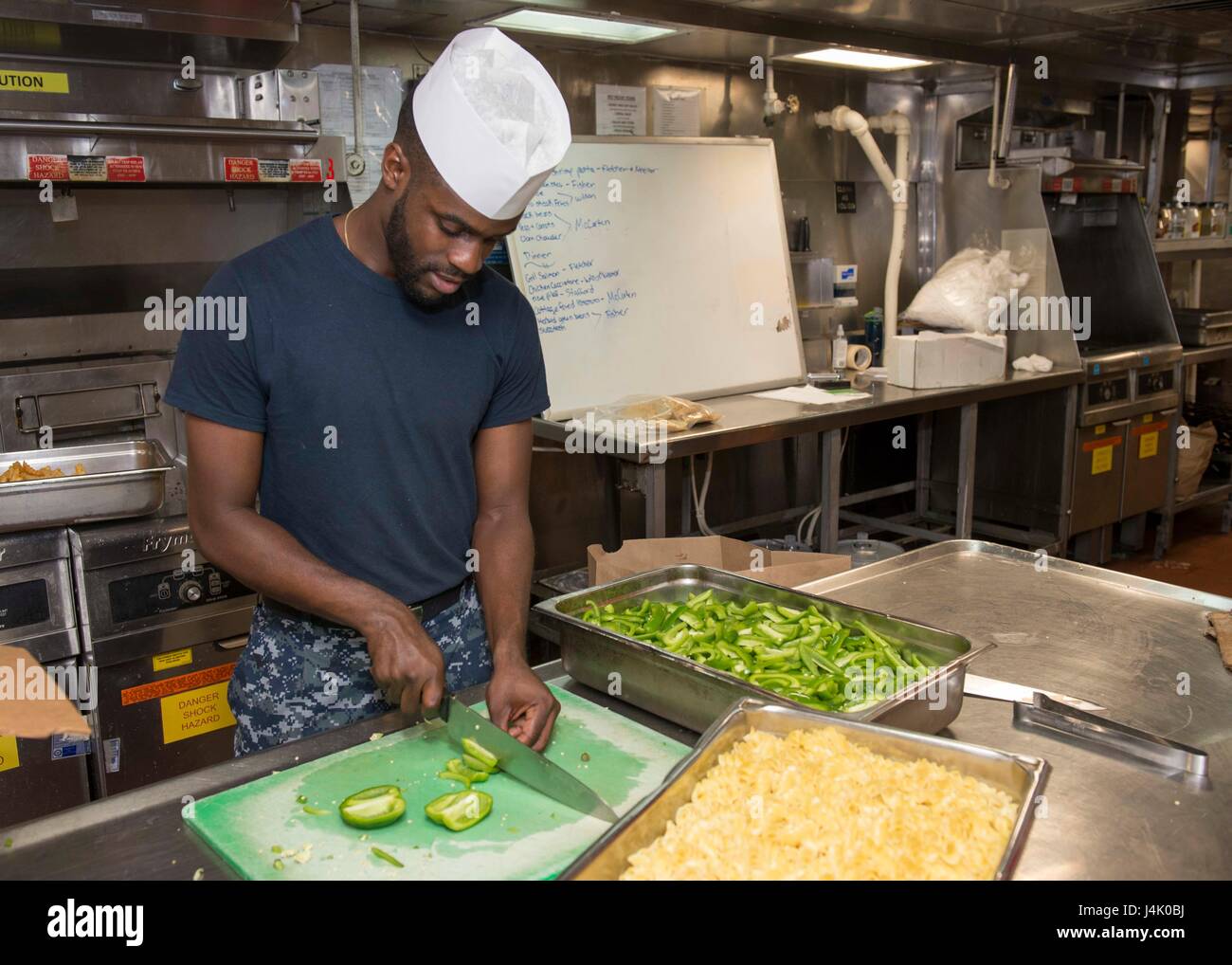 SAN DIEGO (Sept. 30, 2016) Seaman Stephan Neemar chops vegetables in preparation for lunch in the ship’s main galley onboard amphibious assault ship USS Boxer (LHD 4). Boxer returned to its homeport, San Diego, September 12, following a seven-month deployment to the 3rd, 5th, and 7th Fleet areas of operation. (U.S. Navy photo by Petty Officer 3rd Class Jesse Monford/Released) Stock Photo