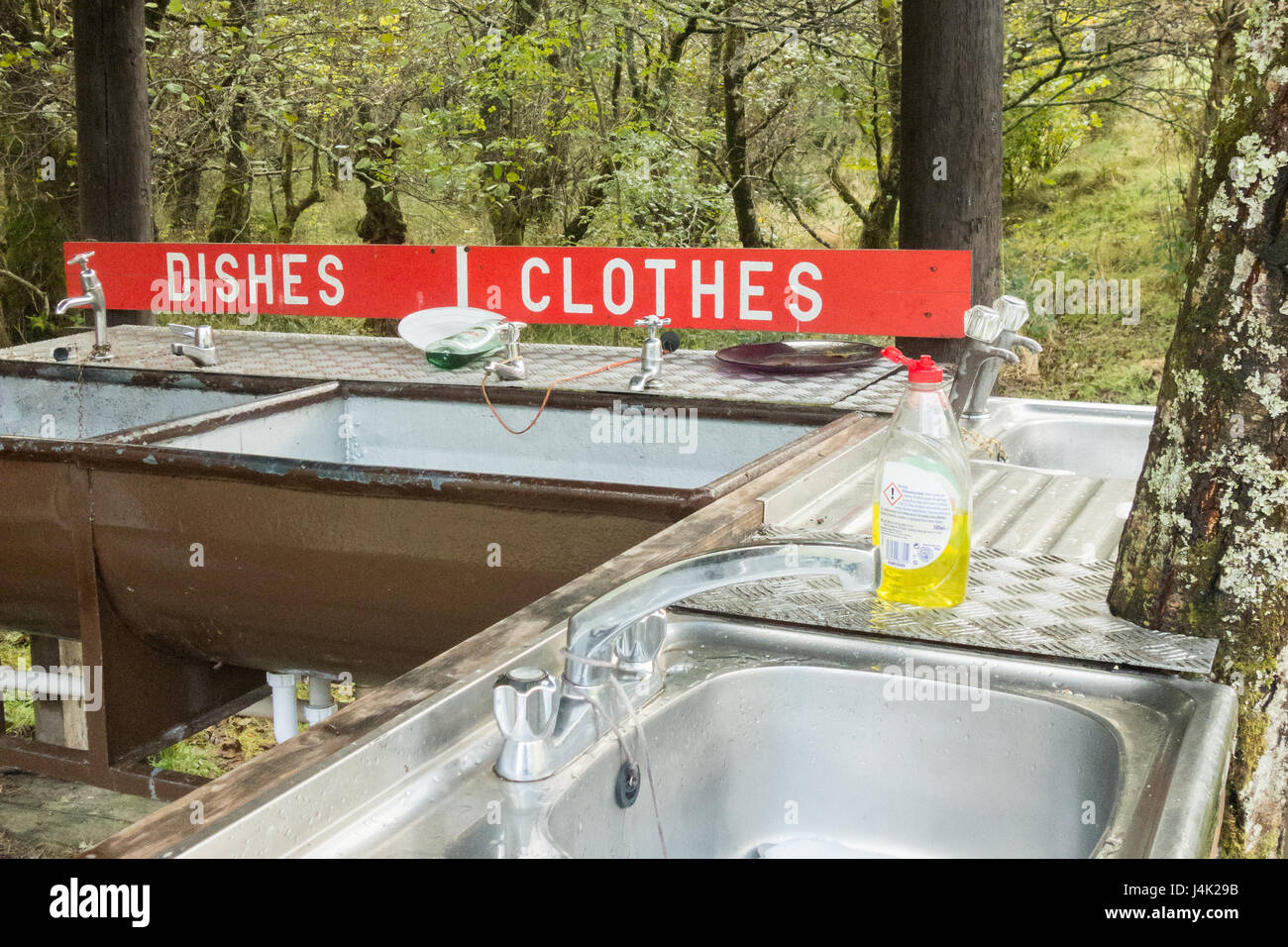washing dishes and clothes by hand - small basic campsite washing up facilities - Red Squirrel campsite, Glencoe, Scotland, UK Stock Photo