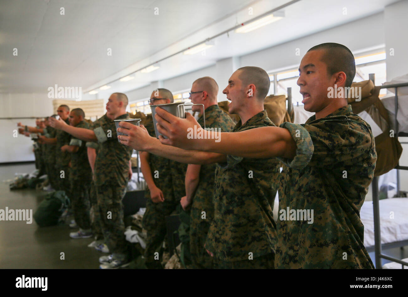 Recruits from Mike Company, 3rd Recruit Training Battalion, hold out their canteen cups during pick up at Marine Corps Recruit Depot San Diego, April 28. The new recruits took part in an initial gear inspection to ensure they had all the required gear and were prepared to begin training. Annually, more than 17,000 males recruited from the Western Recruiting Region are trained at MCRD San Diego. Mike Company is scheduled to graduate July 21. Stock Photo