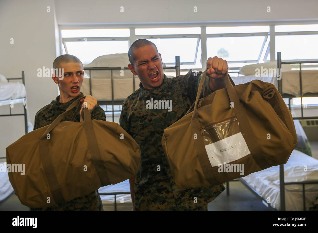 Recruits from Mike Company, 3rd Recruit Training Battalion, hold out their war bags during pick up at Marine Corps Recruit Depot San Diego, April 28. Drill instructors ensure that the recruits fill each bag with the appropriate items and that extra gear is emptied into the recruit’s footlocker. Annually, more than 17,000 males recruited from the Western Recruiting Region are trained at MCRD San Diego. Mike Company is scheduled to graduate July 21. Stock Photo