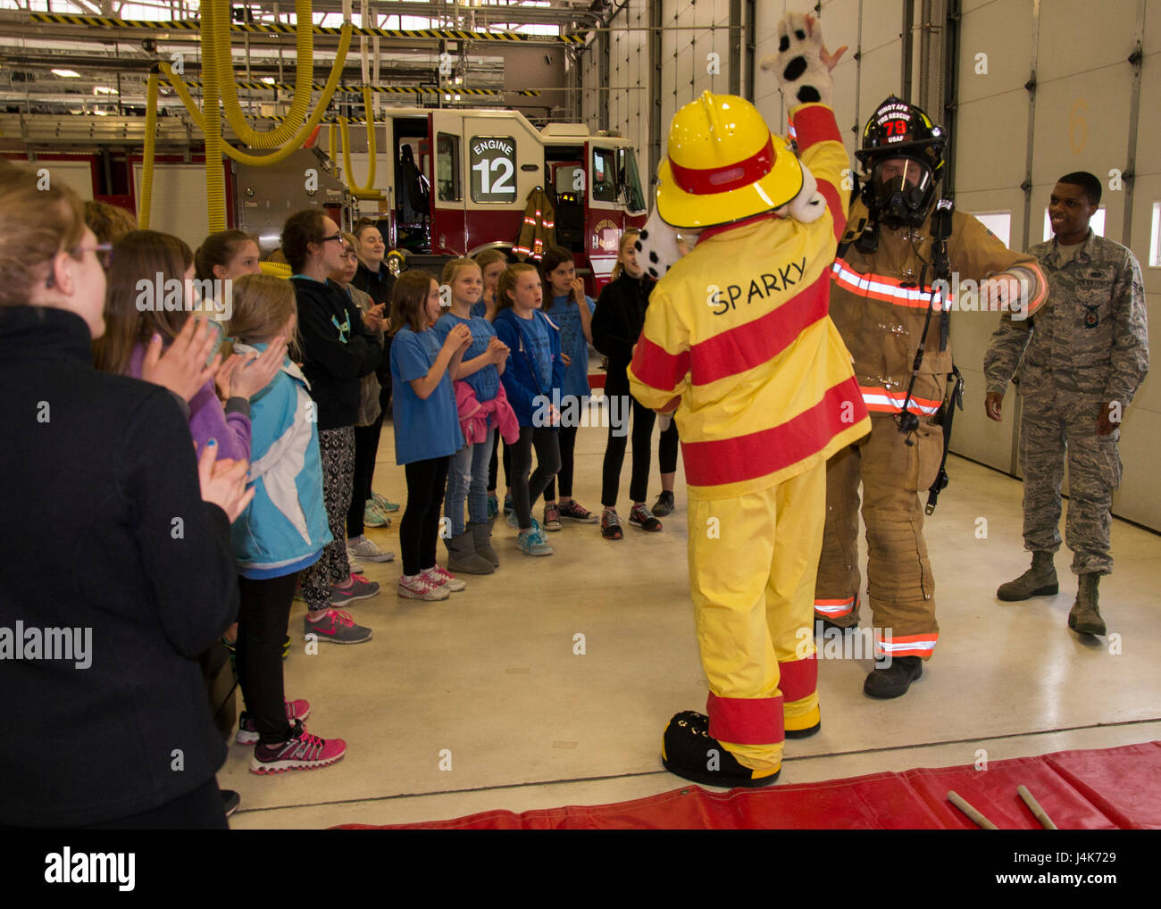 Sparky the Fire Dog highfives a 5th Civil Engineer Squadron
