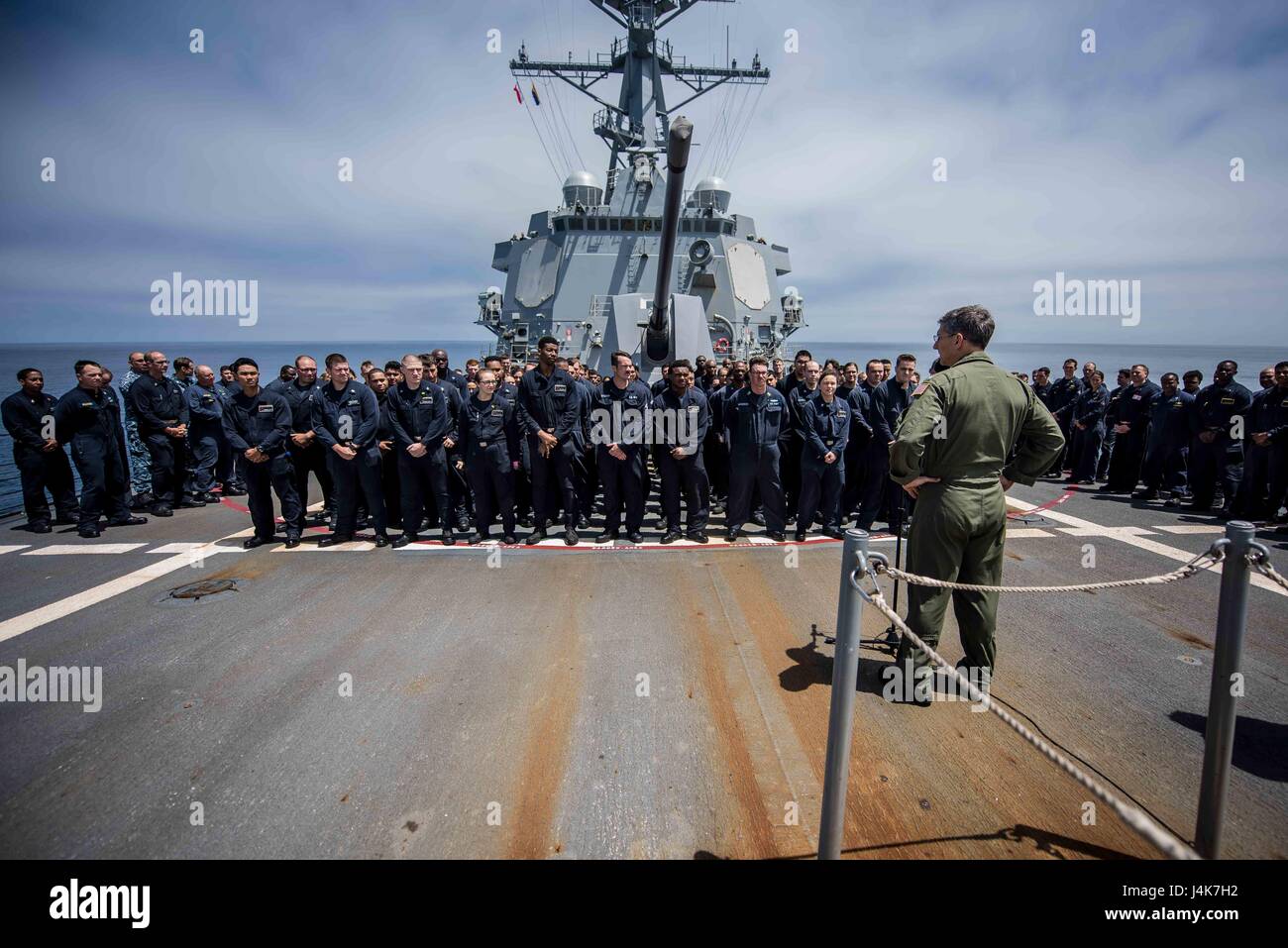 170503-N-TV230-035 PACIFIC OCEAN (May 3, 2017) Rear Adm. James Bynum, commander of Carrier Strike Group (CCSG) 9, speaks to the crew of the guided-missile destroyer USS Halsey (DDG) 97 on the forecastle during a Group Sail training unit exercise (GRUSL) with the Theodore Roosevelt Carrier strike Group (TRCSG). GRUSL is the first step in the Theodore Roosevelt’s integrated training phase and aims to enhance mission-readiness and warfighting capabilities between the ships, airwing and the staffs of the TRCSG through simulated real-world scenarios. (U.S. Navy Photo by Mass Communication Specialis Stock Photo