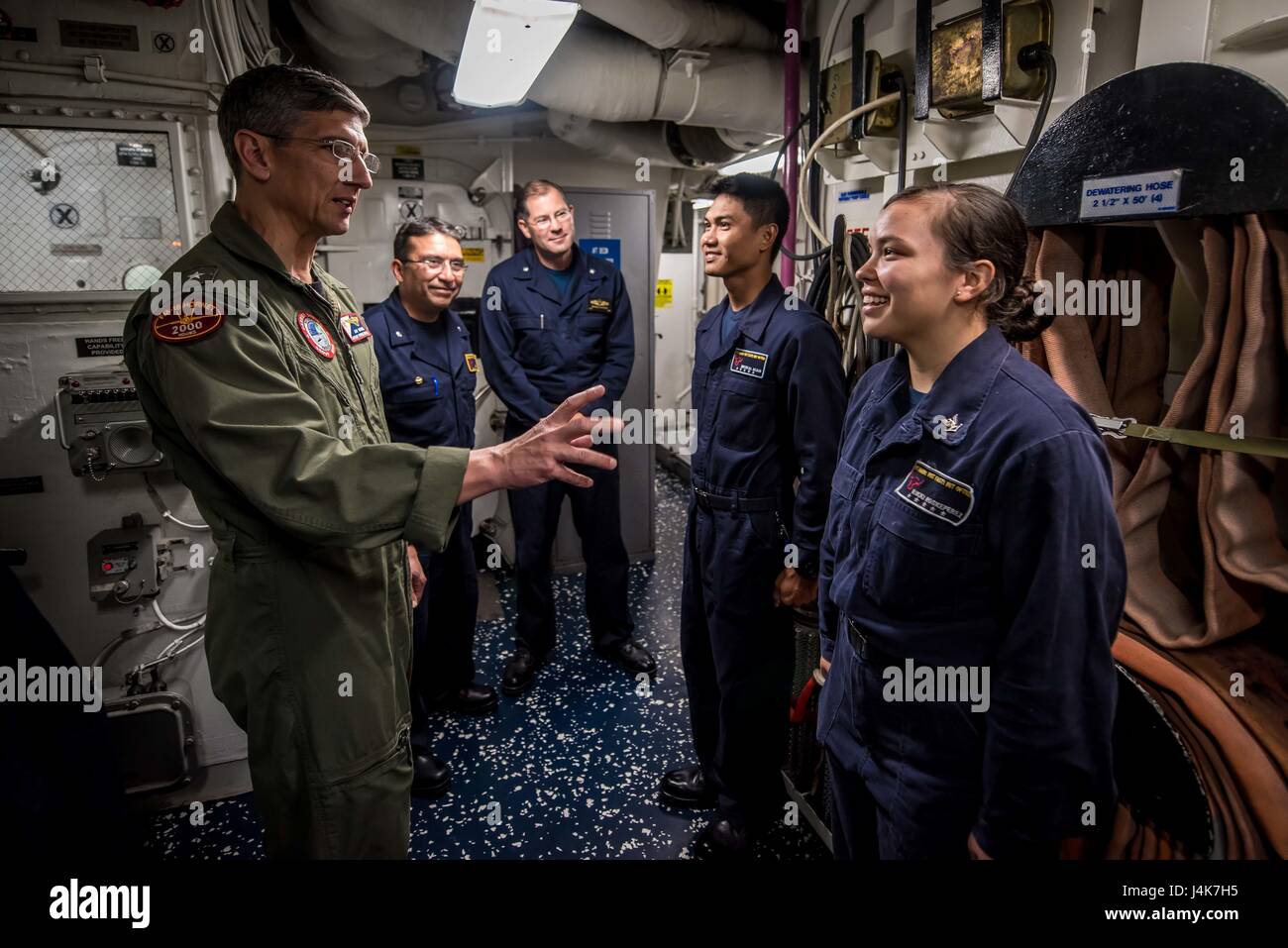 170503-N-TV230-088 PACIFIC OCEAN (May 3, 2017) Rear Adm. James Bynum, commander of Carrier Strike Group (CCSG) 9, speaks to Gas Turbine System Technician (Electrical) 3rd Class Rikki Roskeperez, right, and Logistics Specialist Seaman Michael Acain aboard the guided-missile destroyer USS Halsey (DDG) 97, during a Group Sail training unit exercise (GRUSL) with the Theodore Roosevelt Carrier strike Group (TRCSG). GRUSL is the first step in the Theodore Roosevelt’s integrated training phase and aims to enhance mission-readiness and warfighting capabilities between the ships, airwing and the staffs Stock Photo