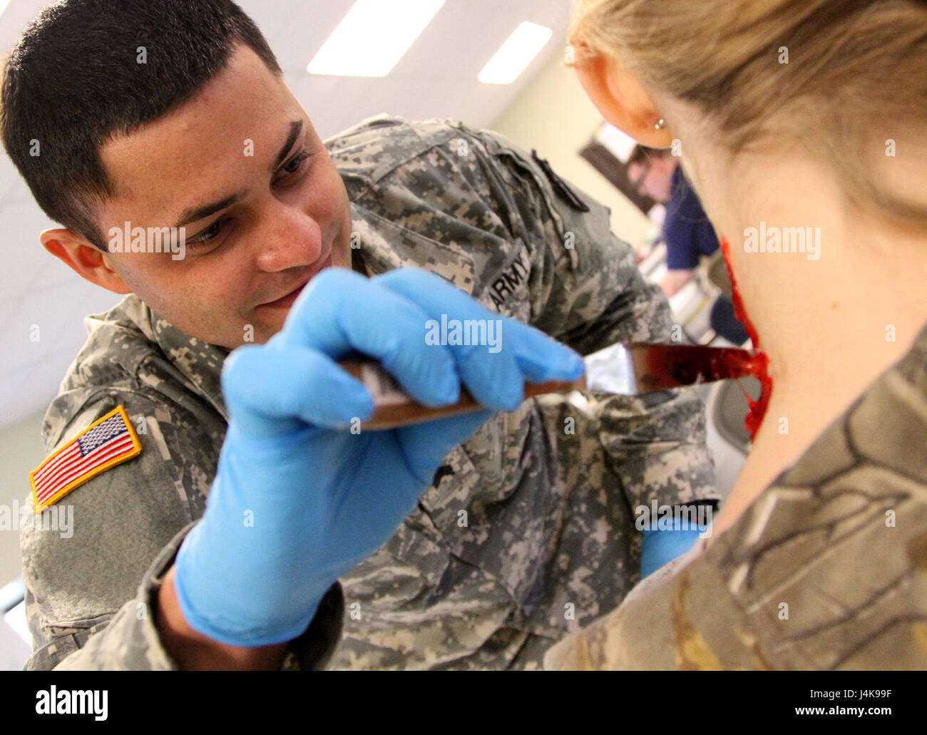 MUSCATATUCK URBAN TRAINING CENTER, Indiana – Sgt. Emmanuel Cabrera from Quebradillas, Puerto Rico, a logistic specialist with the U.S. Army Reserve’s 266th Ordnance Company, Aguadilla, Puerto Rico, creates an artificial laceration wound onto a civilian volunteer at the Muscatatuck Urban Training Center, Indiana, May 6, 2017. Nearly 4,100 Soldiers from across the country are participating in Guardian Response 17, a multi-component training exercise to validate U.S. Army units’ ability to support the Defense Support of Civil Authorities (DSCA) in the event of a Chemical, Biological, Radiological Stock Photo