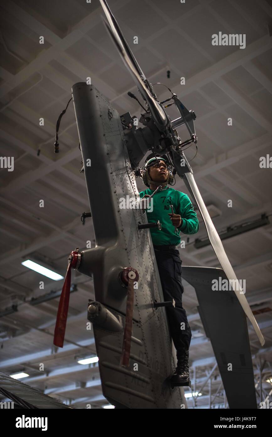 170506-N-VN584-233  PACIFIC OCEAN (May 6, 2017) Aviation Machinist’s Mate 1st Class Elizabeth Pruitt performs maintenance on an MH-60R Sea Hawk helicopter assigned to the 'Battlecats' of Helicopter Maritime Strike Squadron (HSM) 73 in the hangar bay of the aircraft carrier USS Theodore Roosevelt. The ship is participating in a group sail training unit exercise to enhance mission-readiness and warfighting capabilities between the ships, air wing and staffs through simulated real-world scenarios. (U.S. Navy photo by Mass Communication Specialist Seaman Alex Corona/Released) Stock Photo