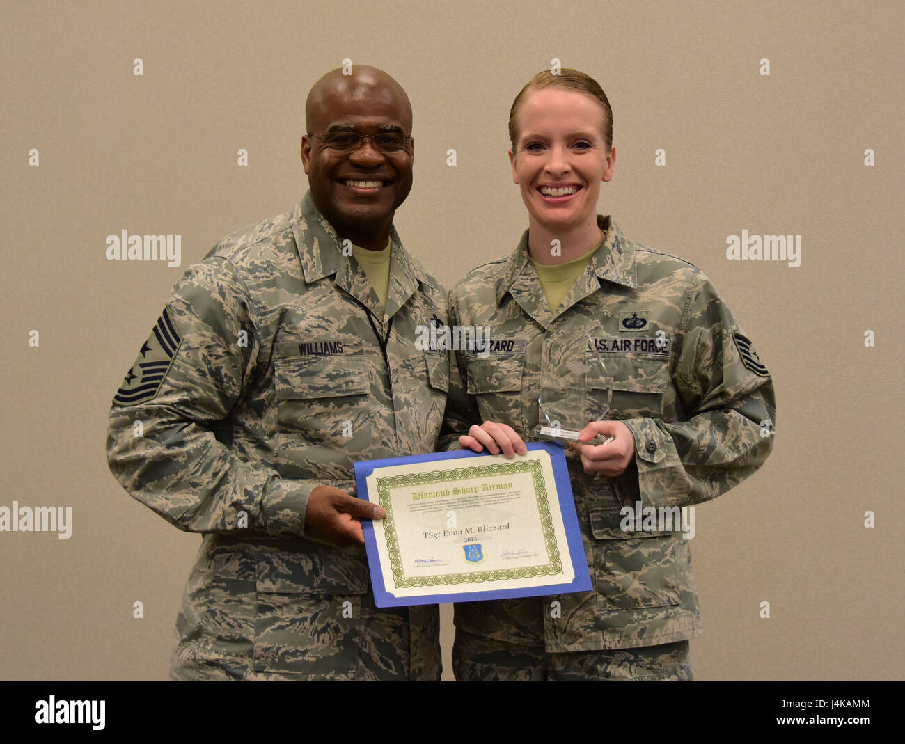 Chief Master Sgt. Benjamin Williams, the command chief master sergeant for the 118th Wing, awards Tech. Sgt. Evon Blizzard from the 118th Wing finance office the Diamond Sharp award for 2015 on May 7, 2017 in Nashville, Tenn. The award, from Williams's last year as a first sergeant, was given to Blizzard for her ability, attitude, and appearance. (U.S. Air National Guard photo by Senior Airman Anthony Agosti) Stock Photo