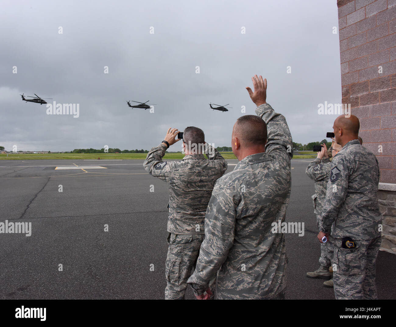 ARMY AVIATION SUPPORT FACILITY, Del. - Members of 166th Security Forces Squadron including Commander Lt. Col. Barry Strube along with Delaware National Guard State Command Chief Master Sgt. Patricia Ottinger, wave to their troops as they fly to Joint Base McGuire-Dix Lakehurst, N.J. on May 7, 2017. A four-ship formation of Blackhawk helicopters from the 238th Aviation Regiment, Delaware National Guard, provided airlift of approximately 40 security forces personnel from the DNG Army Aviation Support Facility to Fort Dix. Delaware Air National Guard security defenders will spend eleven days cond Stock Photo