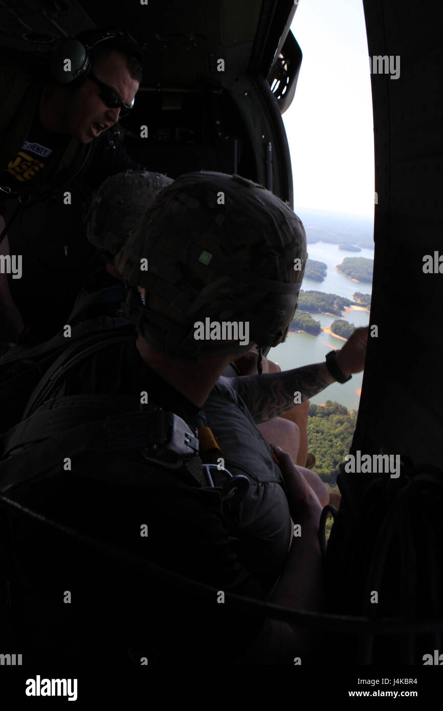 U.S. Army Sgt. 1st Class Cheney, a Ranger Instructor and Jumpmaster with the 5th Ranger Training Battalion (5th RTB), Camp Merrill, Dahlonega, GA, gives the 1-minute warning to jumpers during airborne operations at Lake Lanier, GA, May 9, 2017. 5th RTB is conducting a deliberate airborne operation in order to maintain proficiency in this mission critical task. (photo by Sgt. 1st Class Sean A. Foley) (Not Reviewed) Stock Photo
