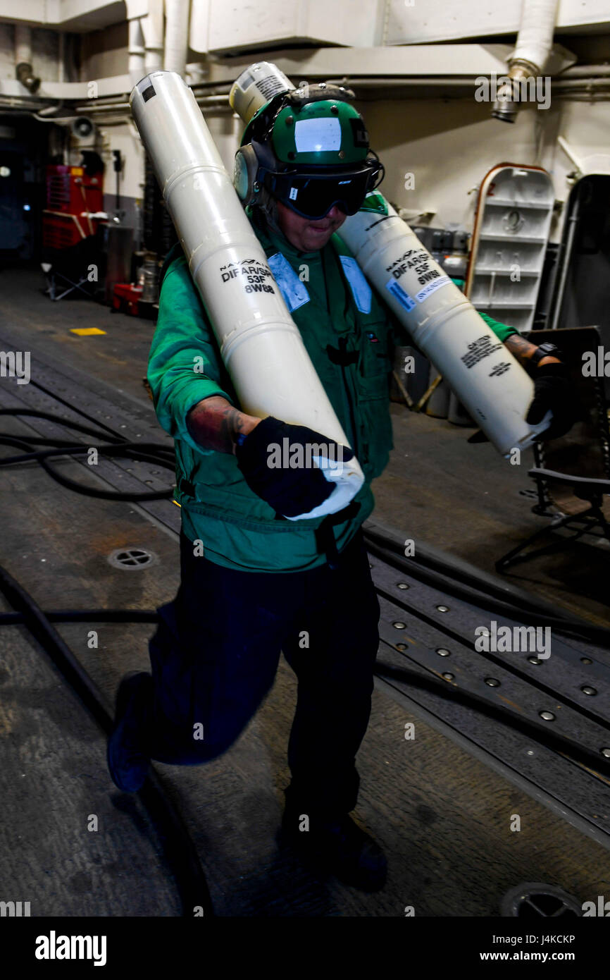 170510-N-AX546-218 BLACK SEA (May 10, 2017) - Aviation Structural Mechanic 2nd Class Daniel Carrilho, from Brasilia, Brazil, carries sonobuoys from the hangar to the flight deck aboard the Arleigh Burke-class guided-missile destroyer USS Oscar Austin (DDG 79) during flight operations May 10, 2017. Oscar Austin is on a routine deployment supporting U.S. national security interests in Europe, and increasing theater security cooperation and forward naval presence in the U.S. 6th Fleet area of operations. (U.S. Navy Photo by Mass Communication Specialist 1st Class Sean Spratt/Released) Stock Photo