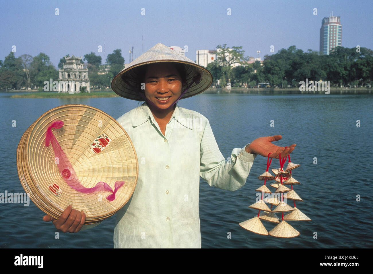 Vietnam, Hanoi, lakeside, souvenir shop assistant, straw hats South-East Asia, town, woman, locals, Vietnamese, care, straw hat, headgear, sales, souvenirs, hats, sell, economy, trade, souvenir sales, background, Hoan Kiem lake Stock Photo