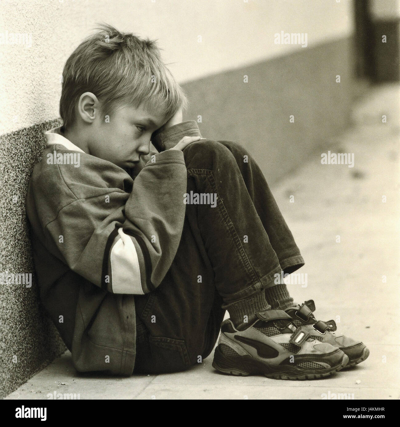 Wall of a house, boy, floor, sit, add support seriously, head, s/w outside, child, tuning, negatively, sadly, dealts with, lonely, only, annoys, anxiously, worried, annoyance, fear, frightened, Shyly, thoughtfully, unhappily Stock Photo