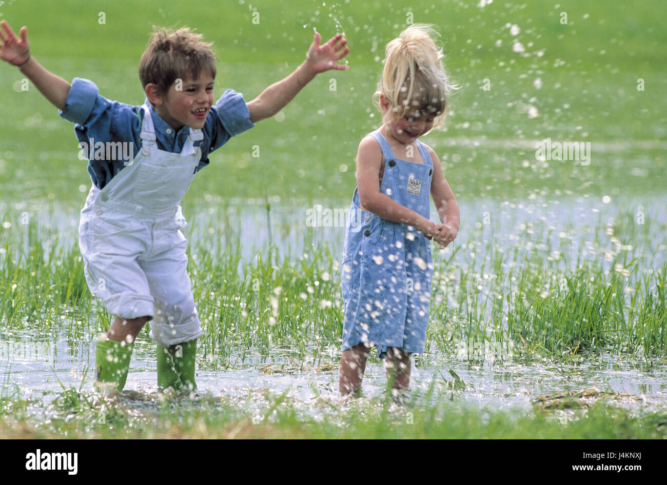 Meadow, water, boy, girl, fun, run summer, holidays, children, friends, two, childhood, carefree nature, brother, sister, siblings, fun, jump, splash, play together, with each other, Stock Photo