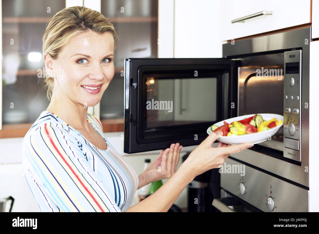 Woman, smile, microwave oven, vegetable plate, heat, portrait, at the side  women's portrait, 20-30 years, housewife, household, housework, cooking,  cooking, warm up, infer, set, hineinstellen, plates, microwave oven,  microwave oven, kitchen utensil,