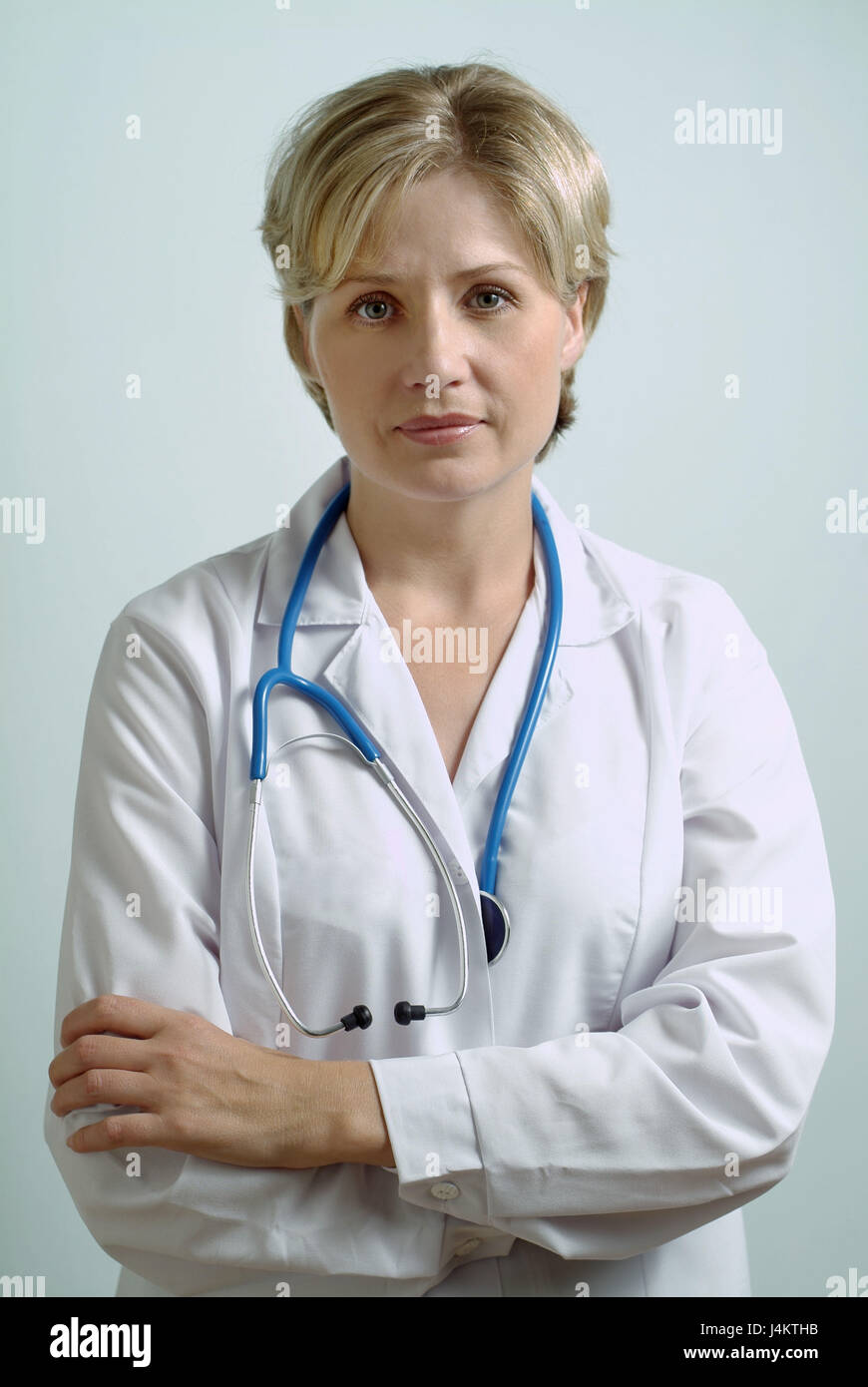 Doctor, stethoscope, arms crossed, seriously, half portrait 30-40 years, blond, view camera, balance, authentically, competently, trust person, doctor, working clothes, working clothes, doctor's smock, work, occupation, remedial occupation, medicine, studio Stock Photo