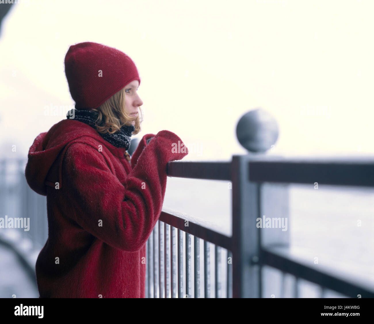 Balustrades, woman, young, winter clothes red, view, thoughtfully 20-30 years, Jung-limited, winter casing, casing, cap, headgear, conception, loneliness, only, exit, sadly, feelings, emotion, unhappily, winter Stock Photo
