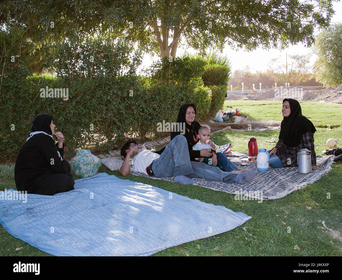 Family picnic in the shade of a 4000-year-old cypress tree near Abarqu, Iran Stock Photo