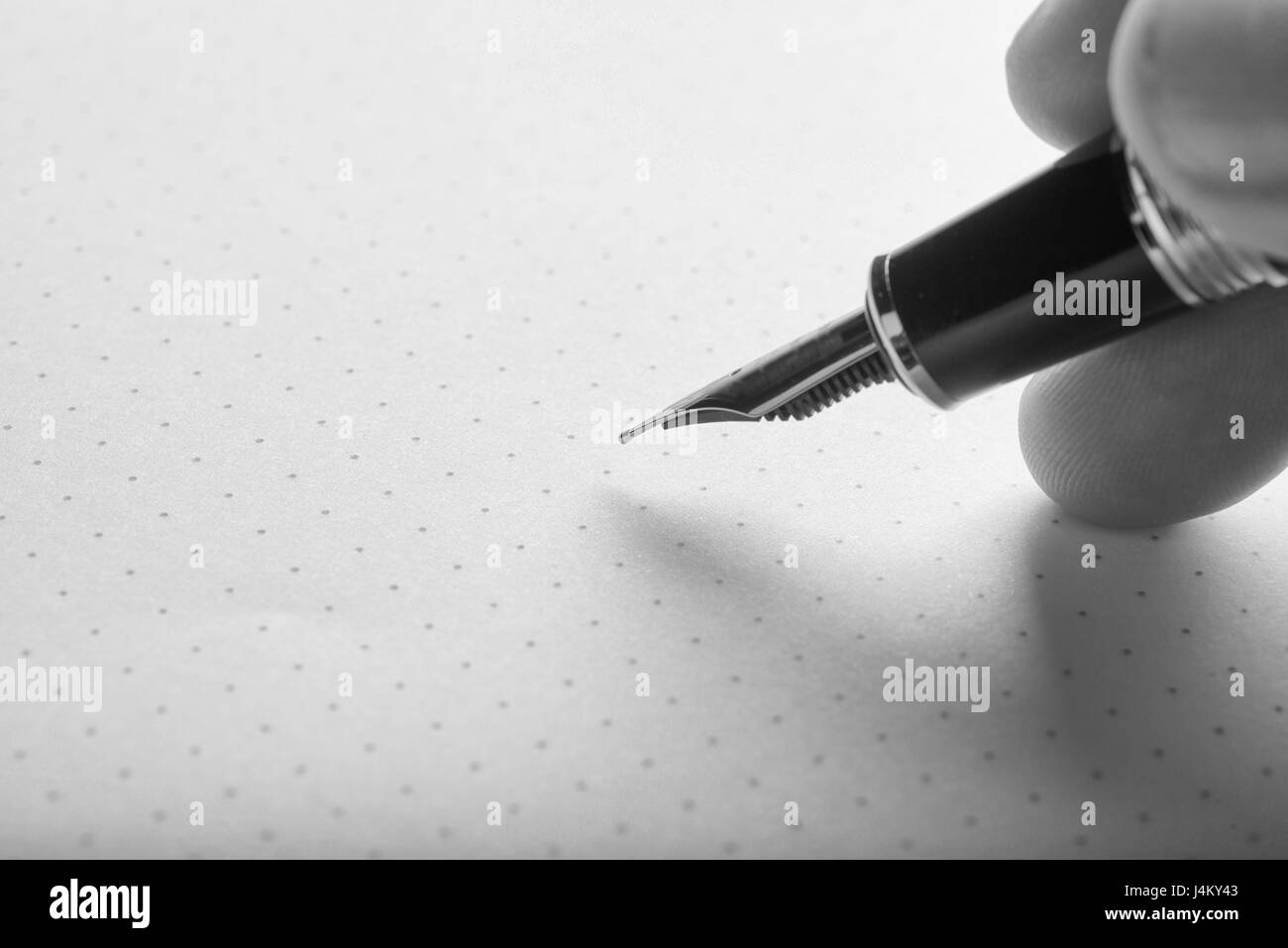 Hand holding a fountain pen to write on paper Stock Photo - Alamy