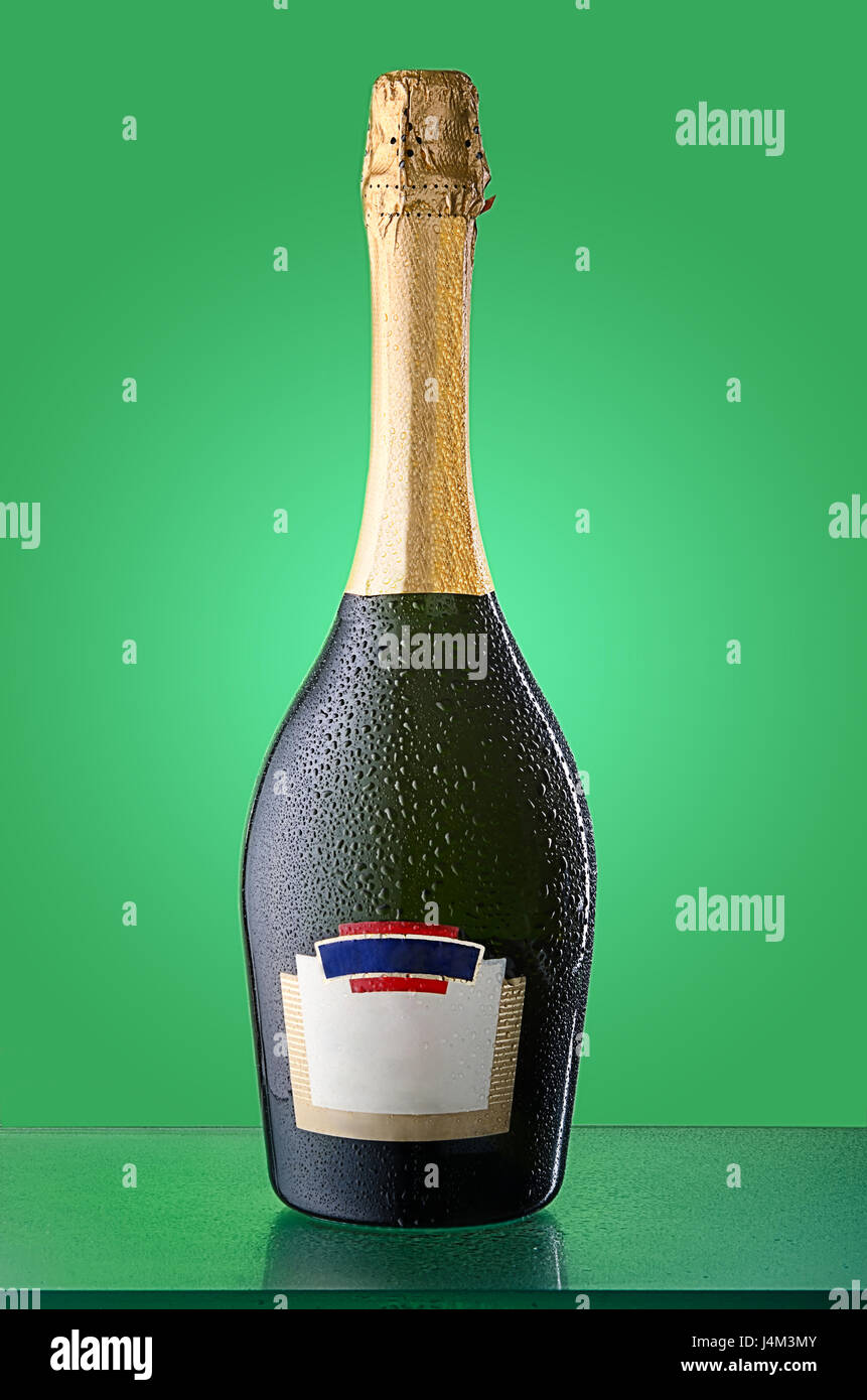 Corked cold bottle of sparkling wine with condensation and reflection. Empty label, logos removed. Stock Photo