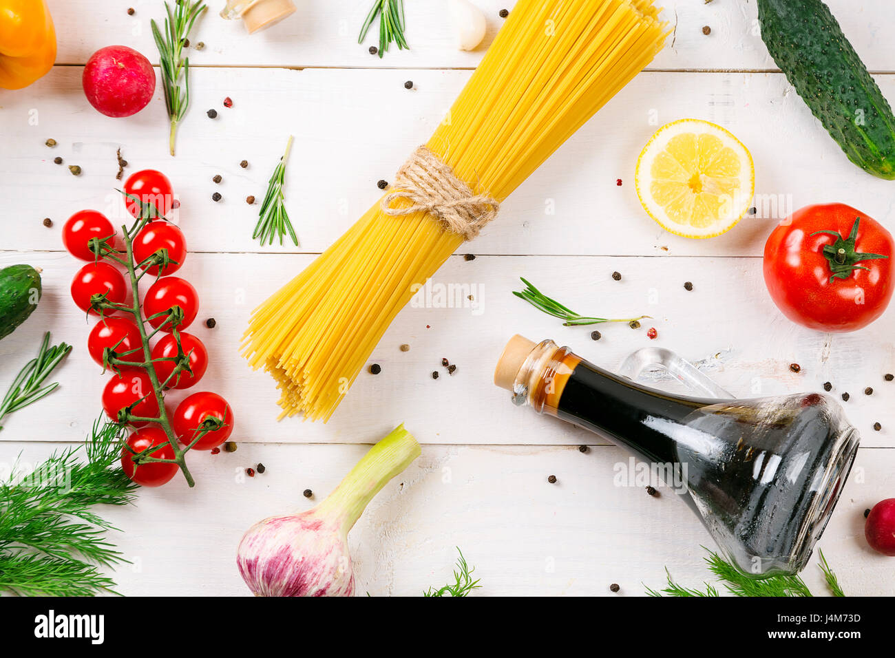 Spaghetti, tomatoes cherry, olive oil, herb and spices on old white