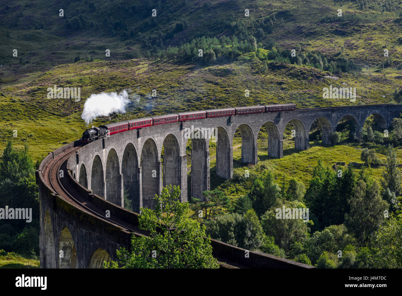 Jacobite steam train on Glenfinnan Viaduct approaching. Highlands, Scotland, United Kingdom Stock Photo