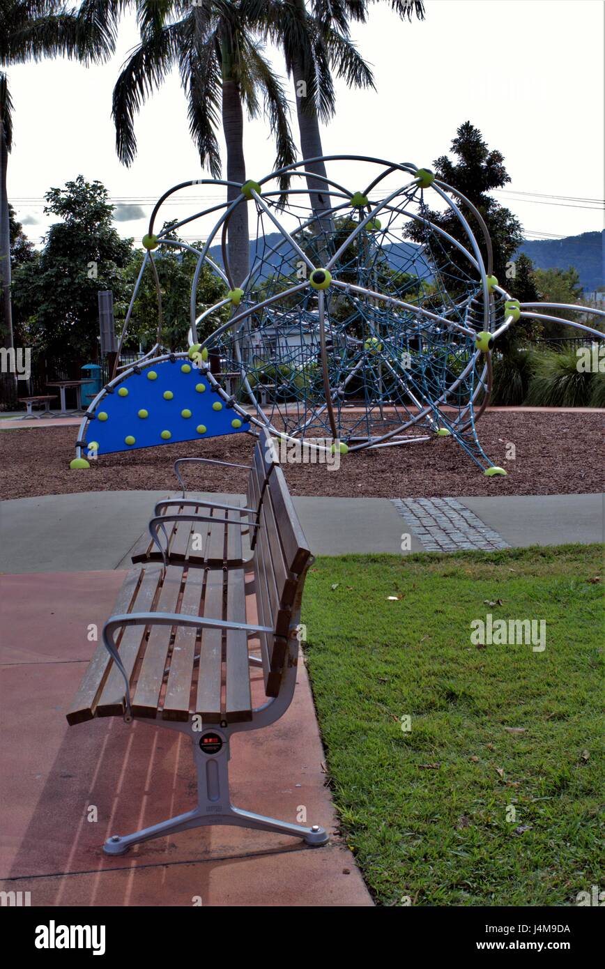Kids park in Australia. Children park with rides made of metal and ropes, grass, trees, benches in view. Stock Photo