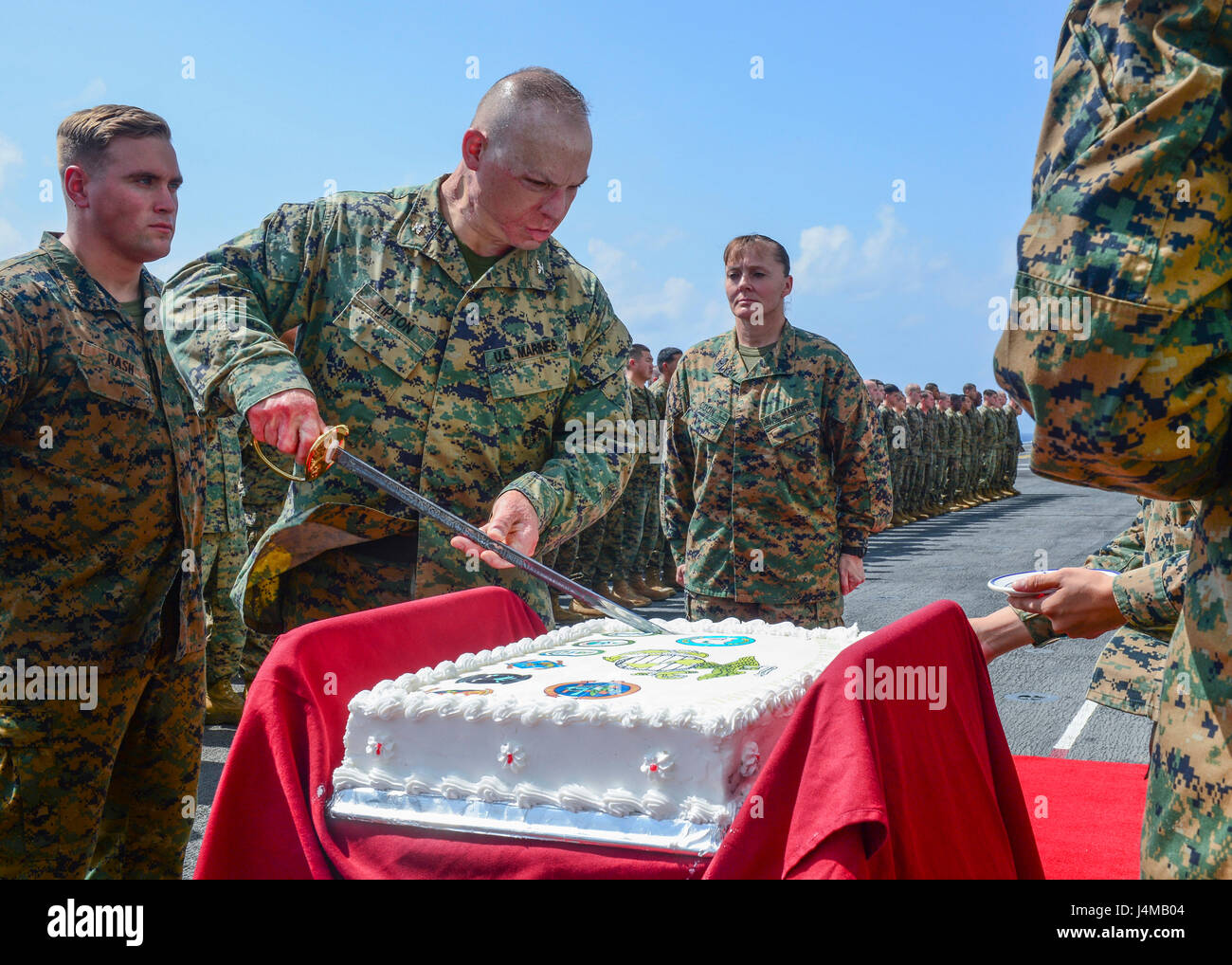 161110-N-LI768-174 SOUTH CHINA SEA (Nov. 10, 2016) Col. Clay Tipton, commanding officer of the 11th Marine Expeditionary Unit (MEU), ceremoniously cuts a cake during the 241st Marine Corps birthday celebration on the flight deck of the amphibious assault ship USS Makin Island (LHD 8). Makin Island, the flagship of the Makin Island Amphibious Ready Group, is operating in the U.S. 7th Fleet area of operations with the embarked 11th MEU in support of security and stability in the Indo-Asia-Pacific region. (U.S. Navy photo by Petty Officer 3rd Class Devin M. Langer/Released) Stock Photo