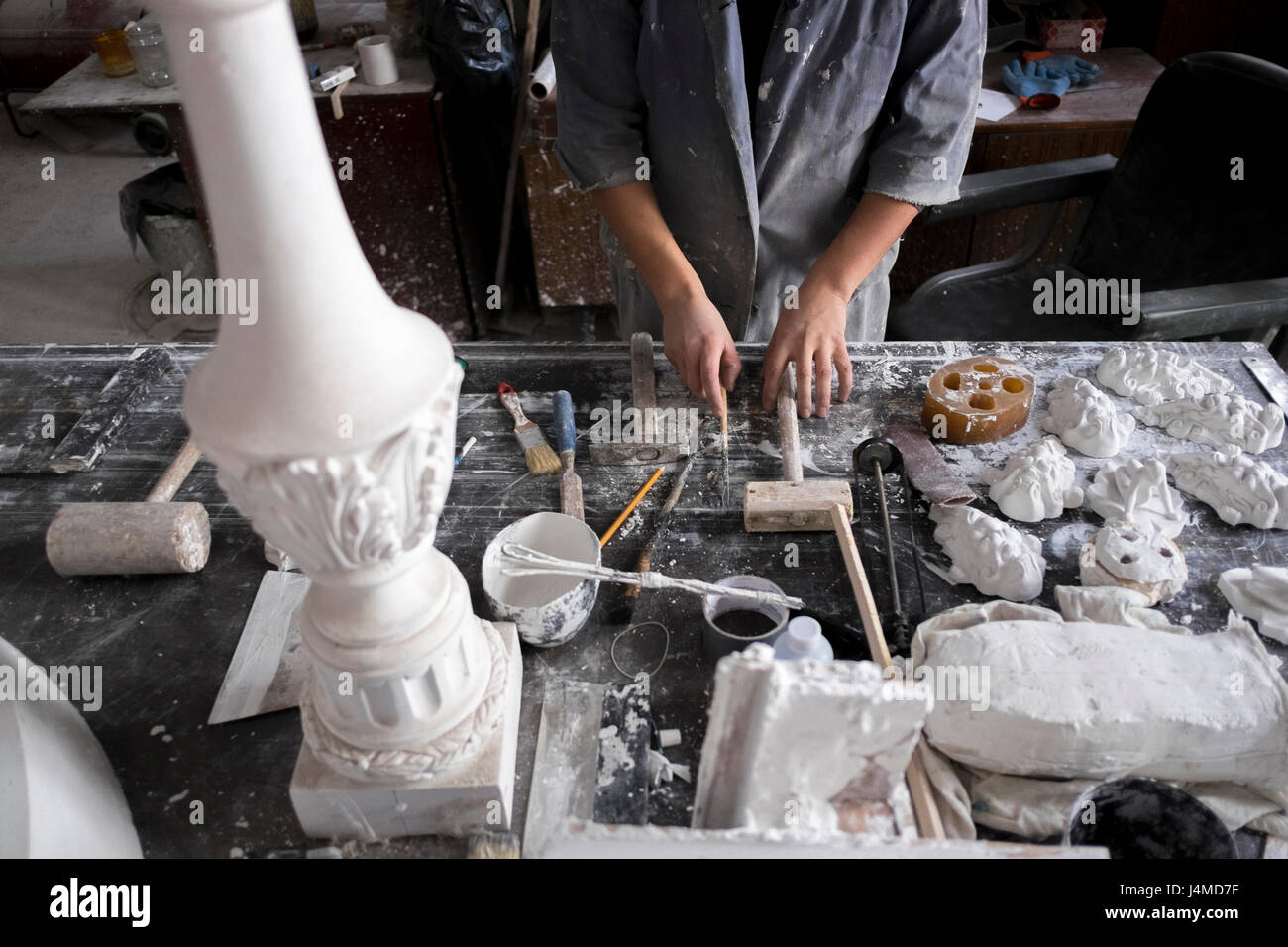 Hands of Caucasian sculptor holding tools Stock Photo