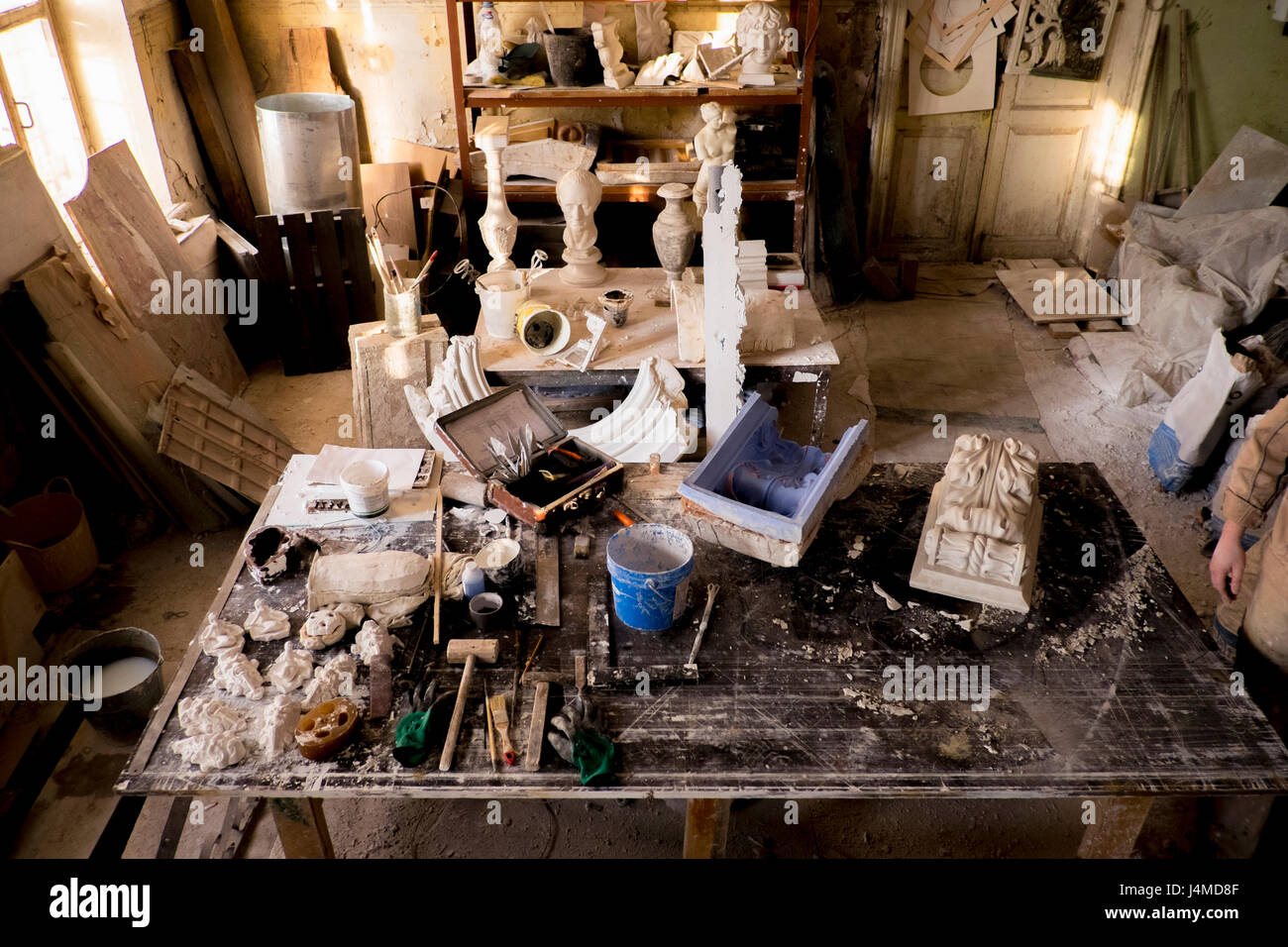 Caucasian artist in messy studio Stock Photo