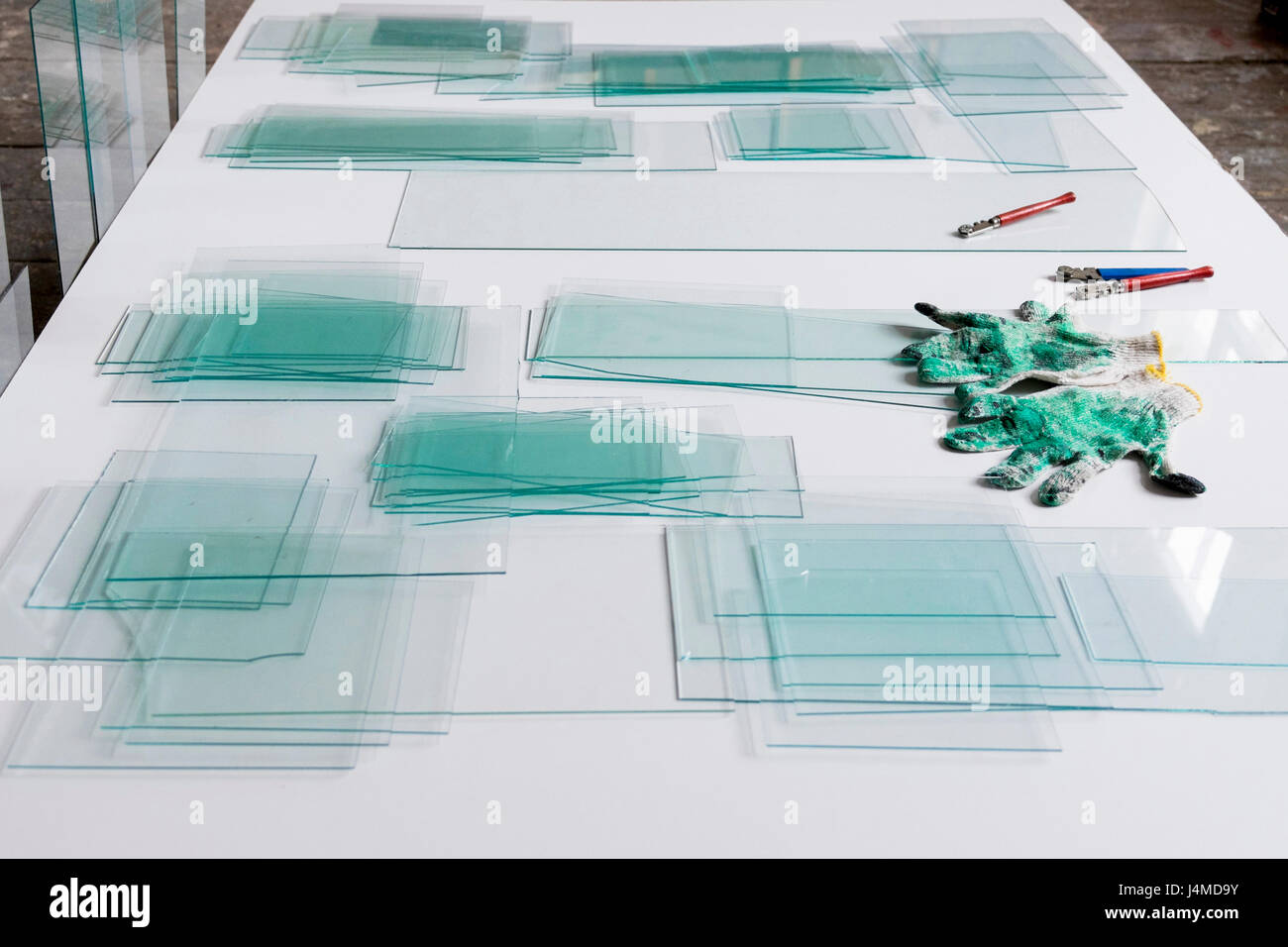 Piles of glass and glass cutter on white table Stock Photo