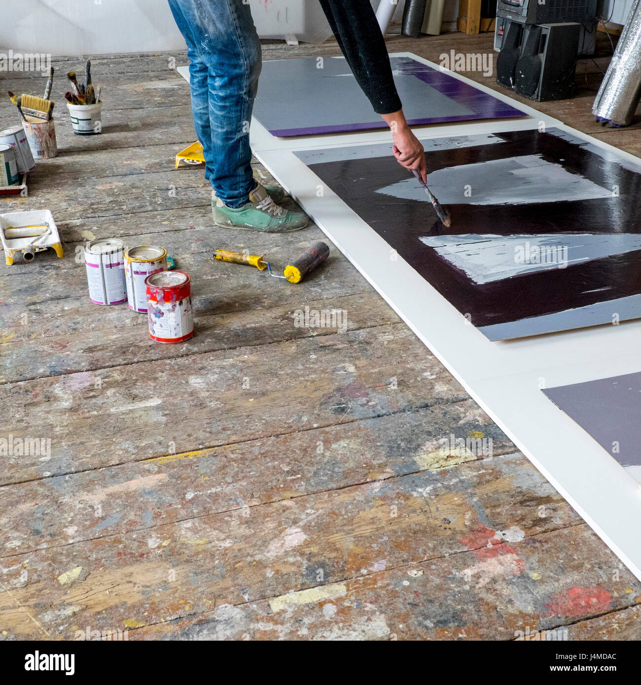 Caucasian artist painting with paintbrush Stock Photo