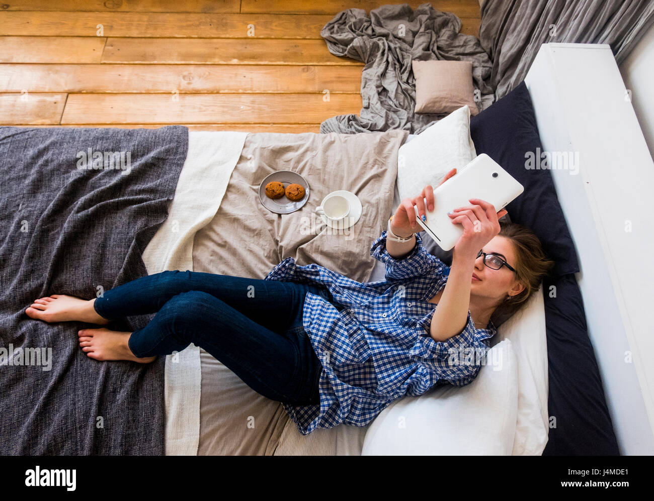 Caucasian woman laying on bed posing for selfie with digital tablet Stock Photo