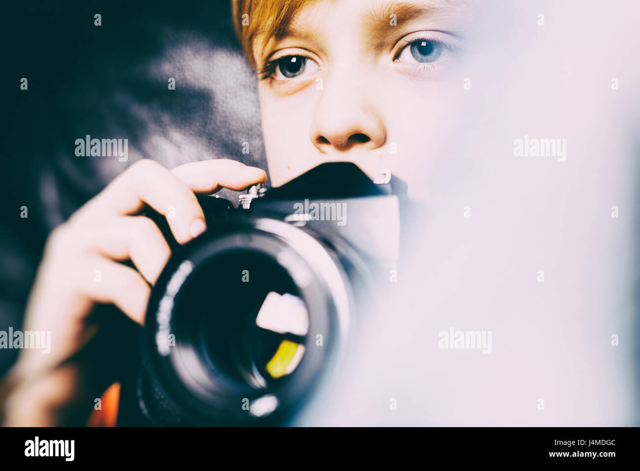 Close up of Caucasian boy holding camera Stock Photo