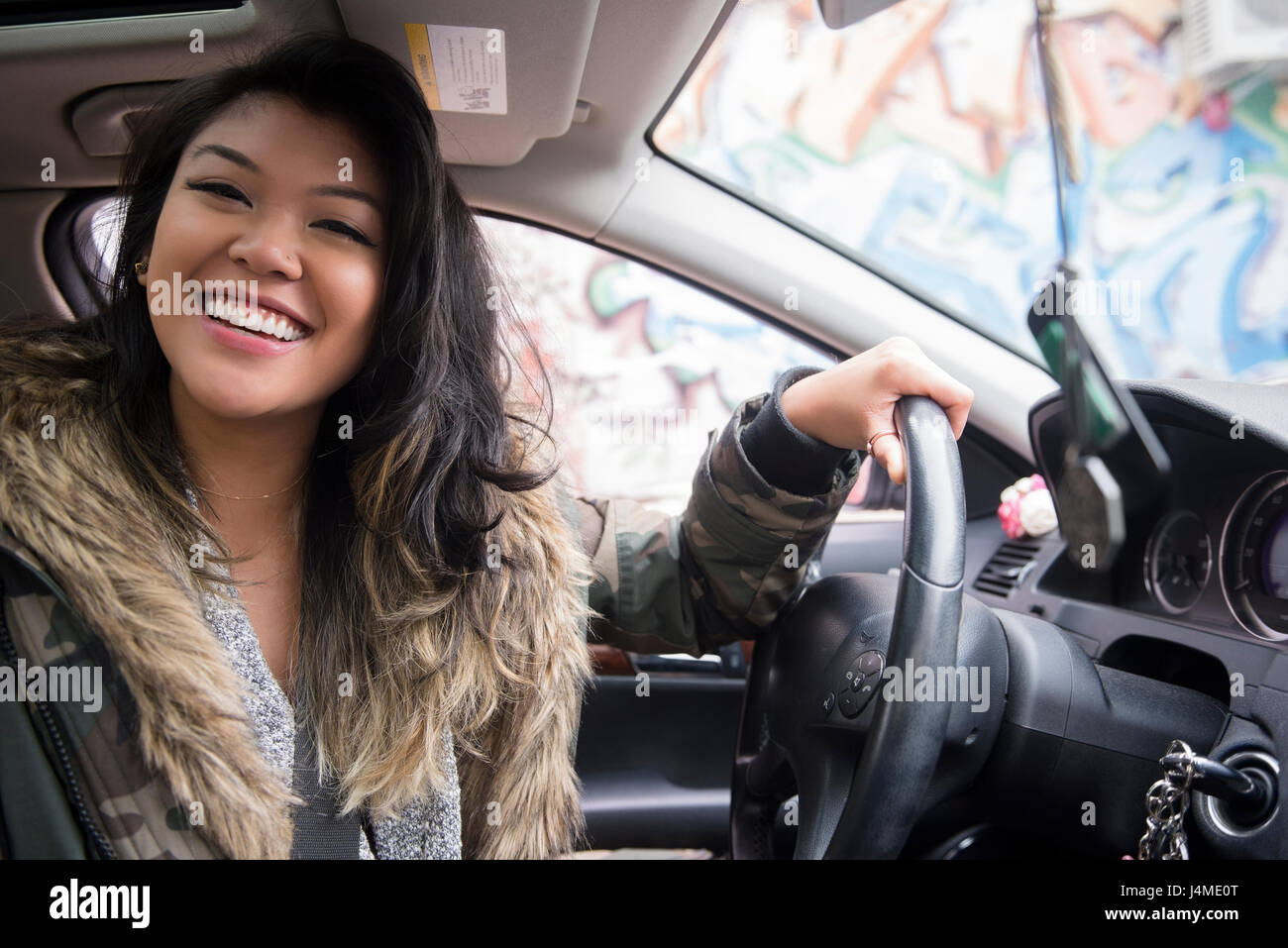 Portrait of smiling Mixed Race woman driving car Stock Photo