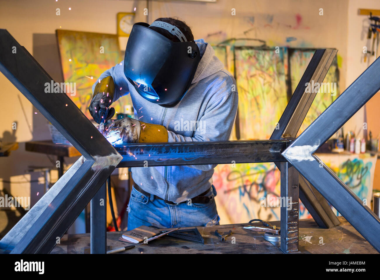 Caucasian man welding metal sculpture Stock Photo