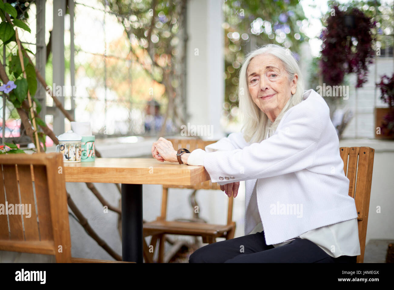 Portrait of smiling older Caucasian woman sitting at table Stock Photo