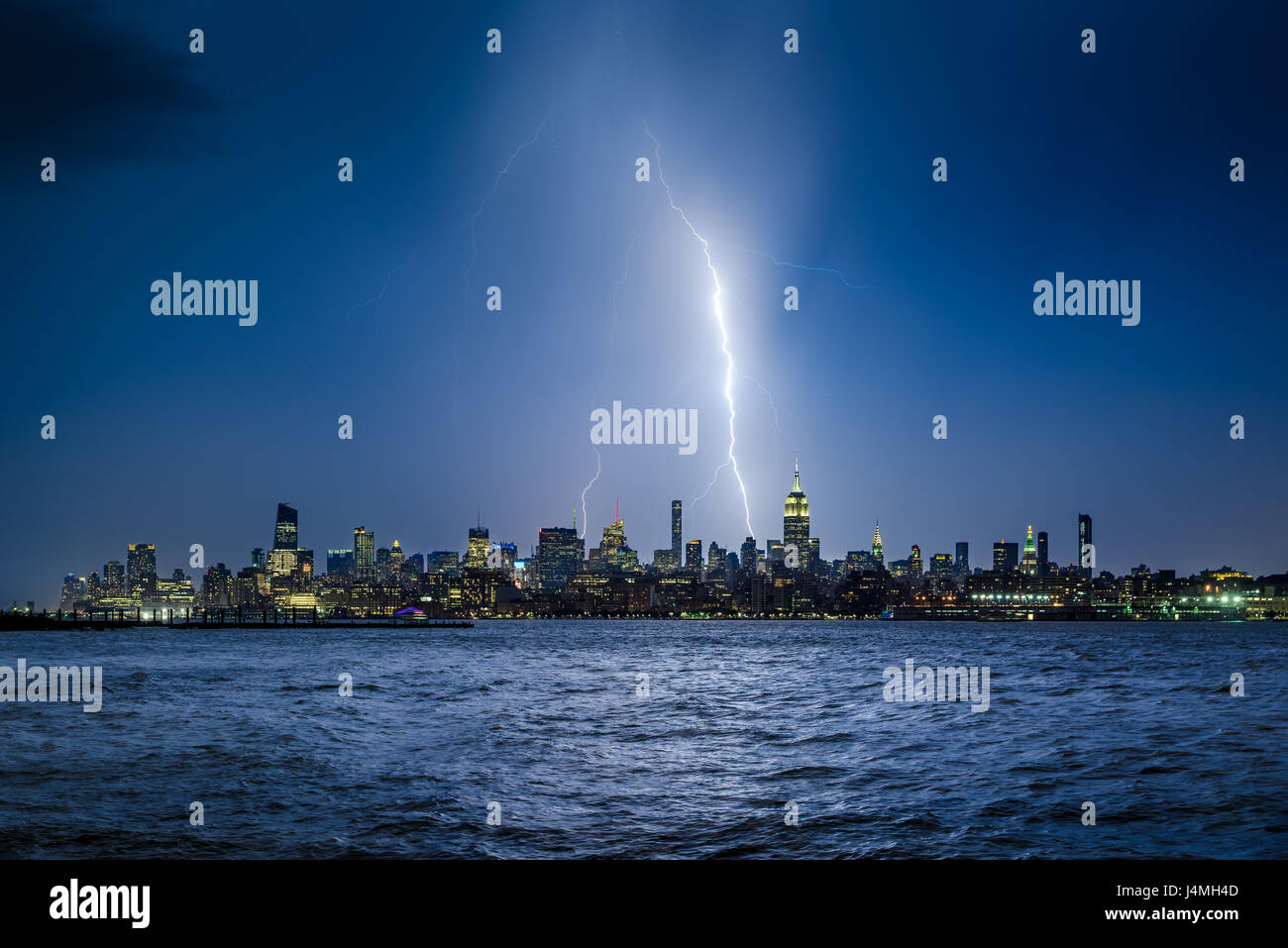 Lightning striking New York City skyscrapers at night. Stormy skies ...