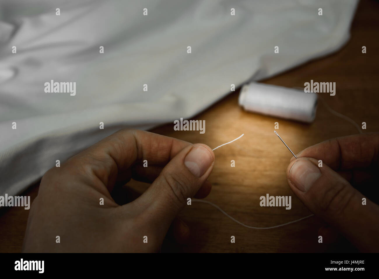 Thread into the needle Stock Photo Alamy