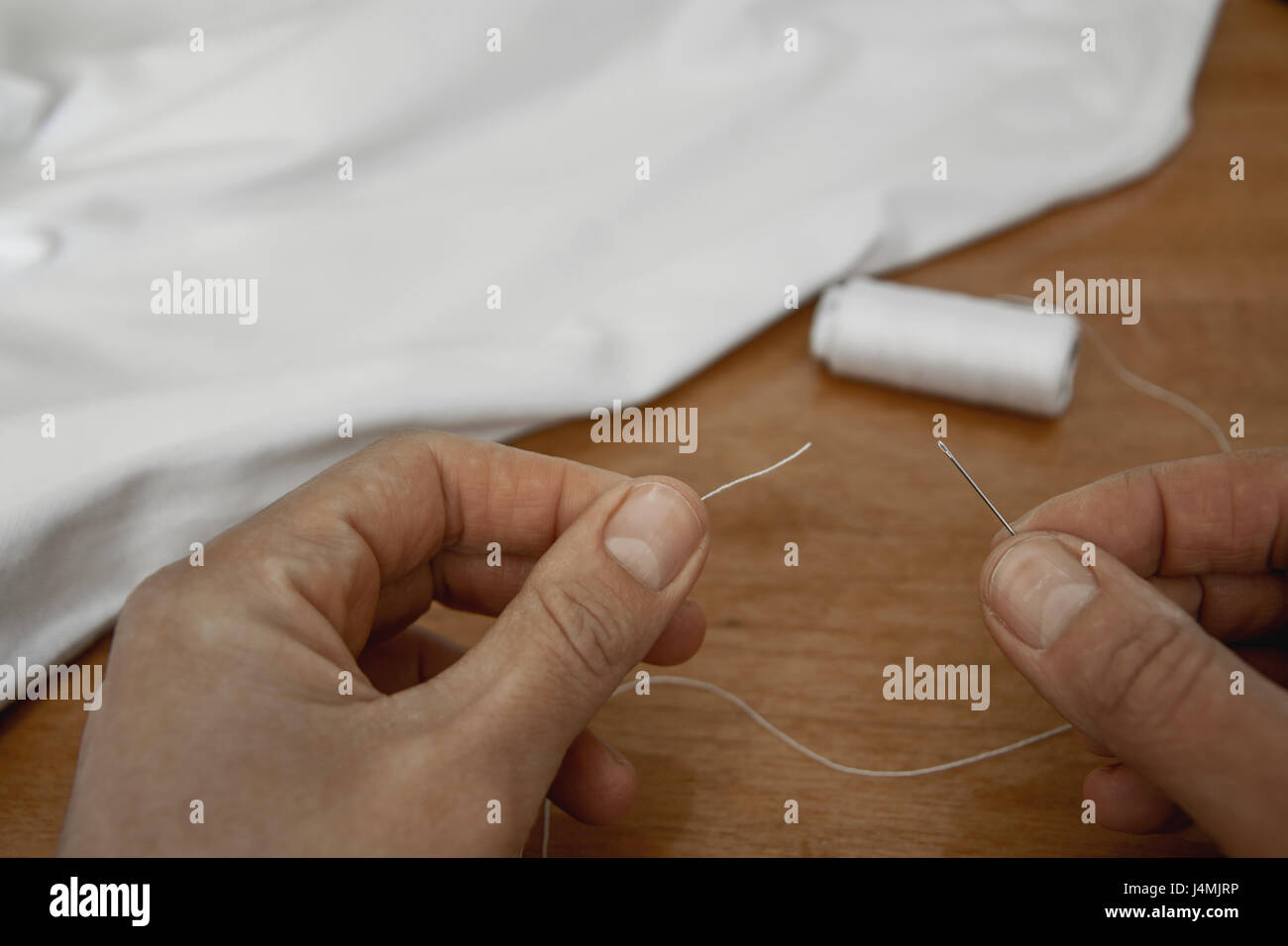 Thread into the needle Stock Photo Alamy