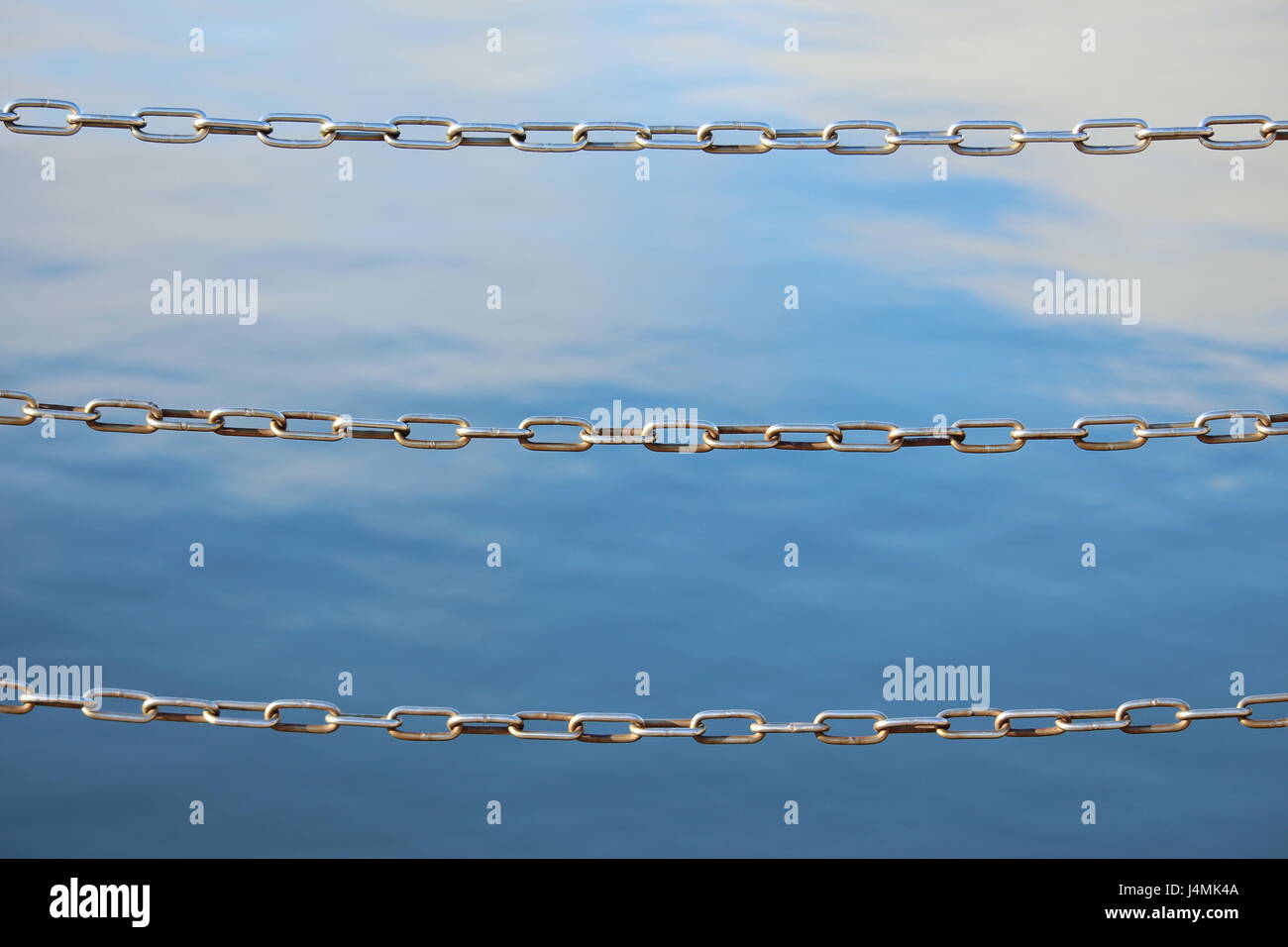 Chain link fencing, with sunny reflections in water background Stock ...