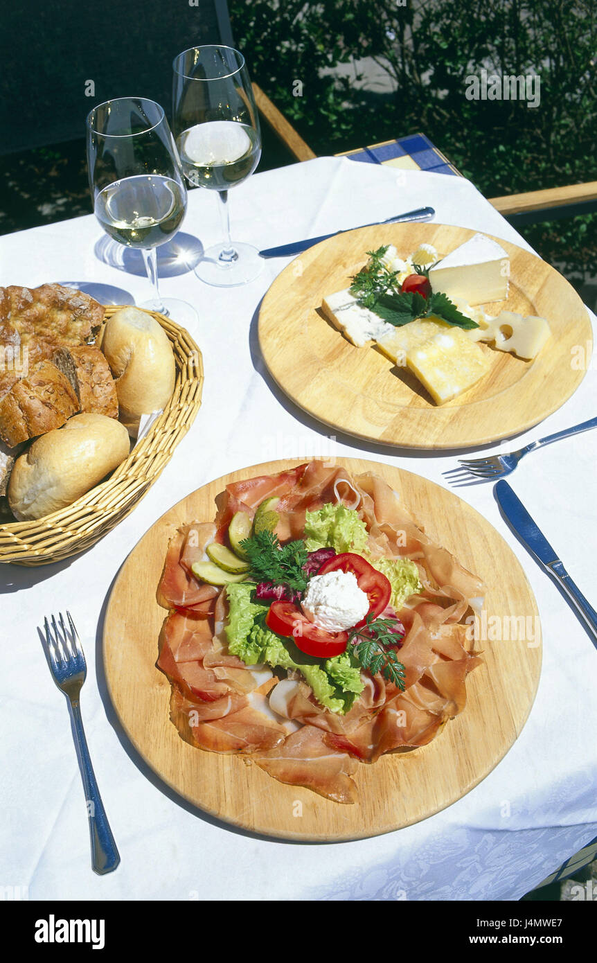 Italy, South Tirol, Villnösstal, restaurant, snack plate, bacon, cheese, bread roll Europe, Southern Europe, Northern Italy, Val de Funes, restaurant, mountain inn, table, wooden boards, bacon, cheese sorts, bread, buns, bread sorts, snack, snack, intermeal, hunger, food, nutrition, wine, white wine, typically for country Stock Photo