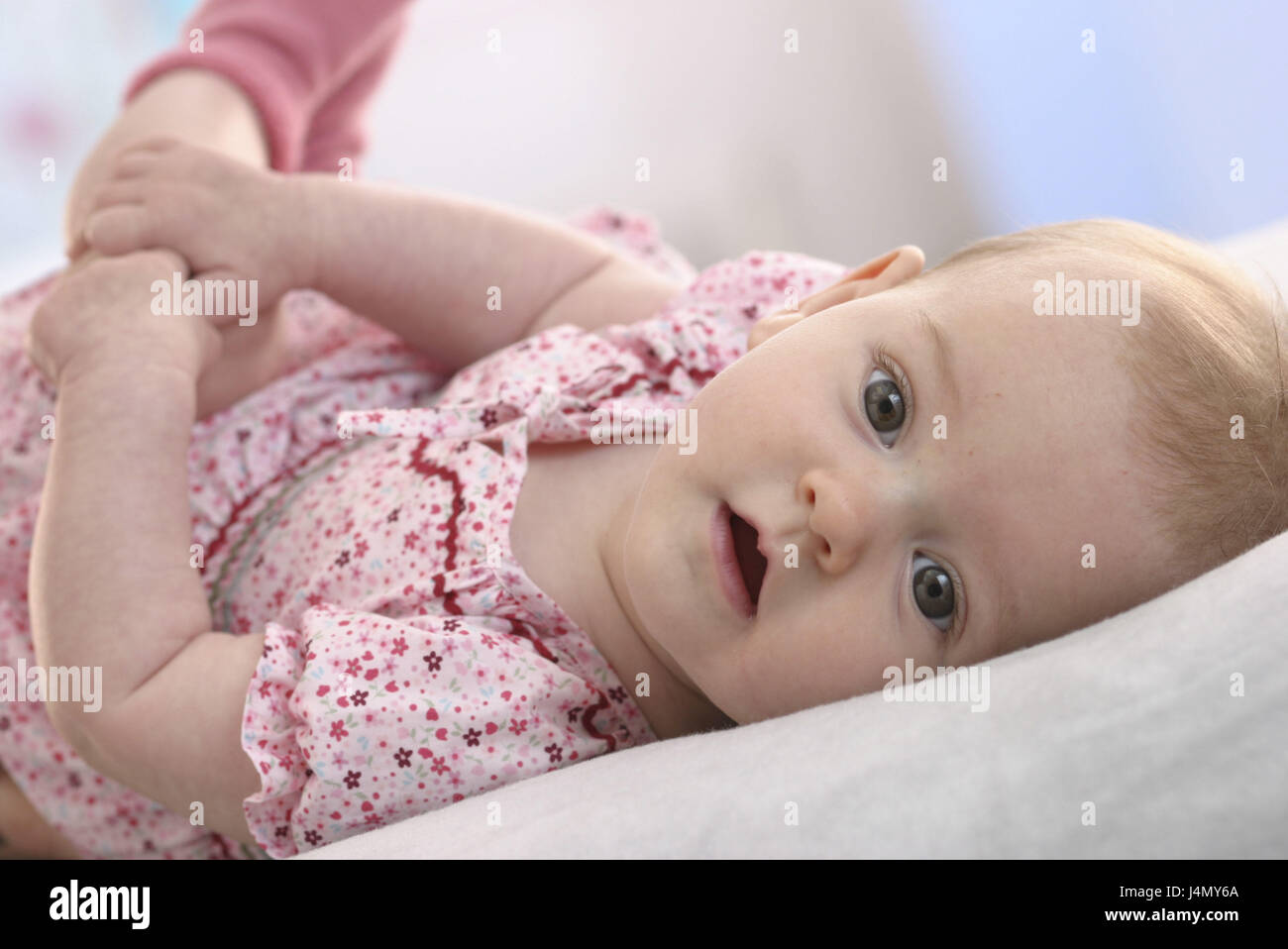 Baby, lie, observe, half portrait child, small, 4 months, infant, blond, girls, dress, back position, brightly, carefully, interest, curiosity, inside, curled, conception, senses, sight, childhood, attention, astonishment, Stock Photo