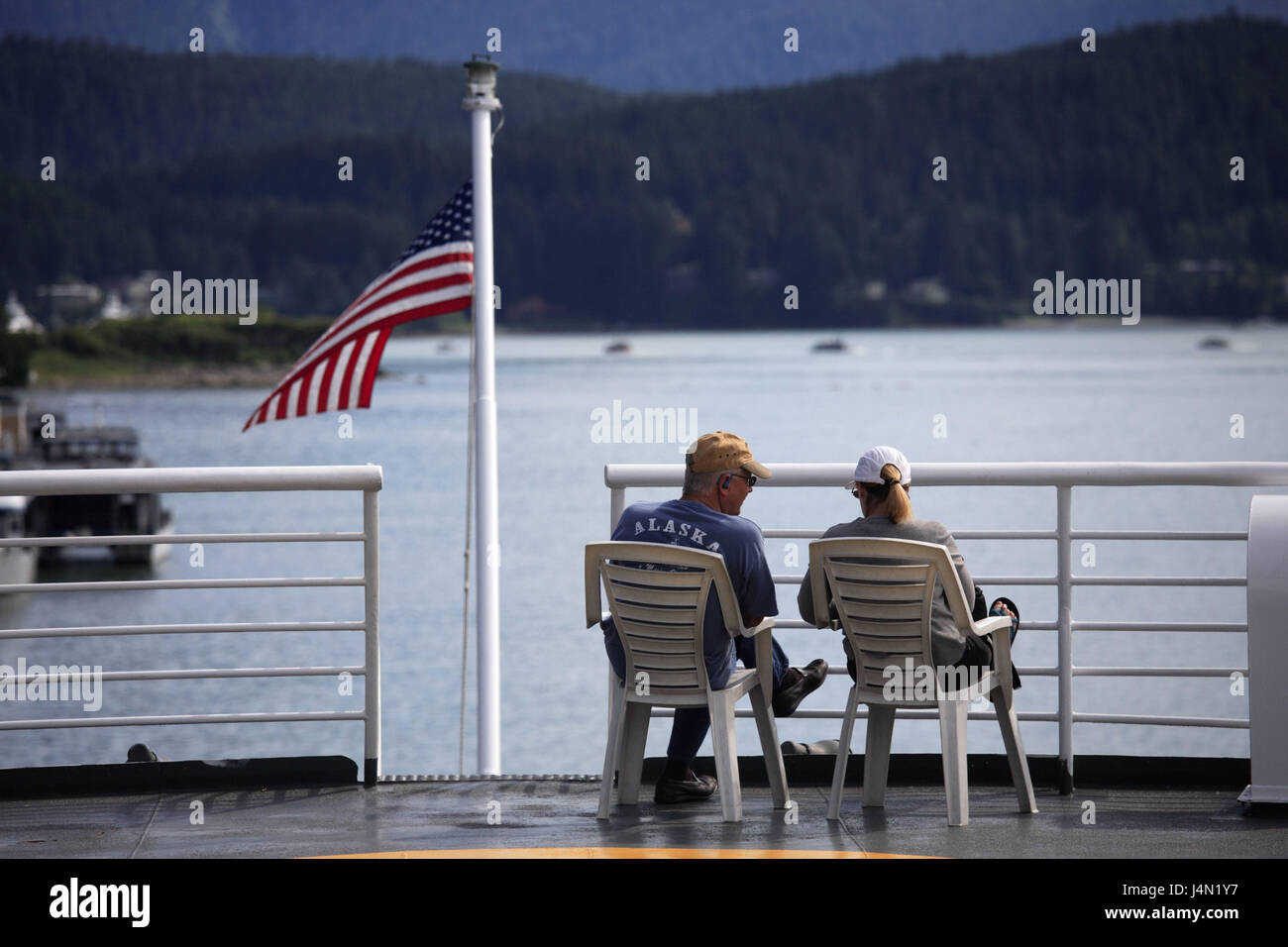The USA, Alaska, ferry, deck, couple, sit, back view, coast, sea, Stock Photo