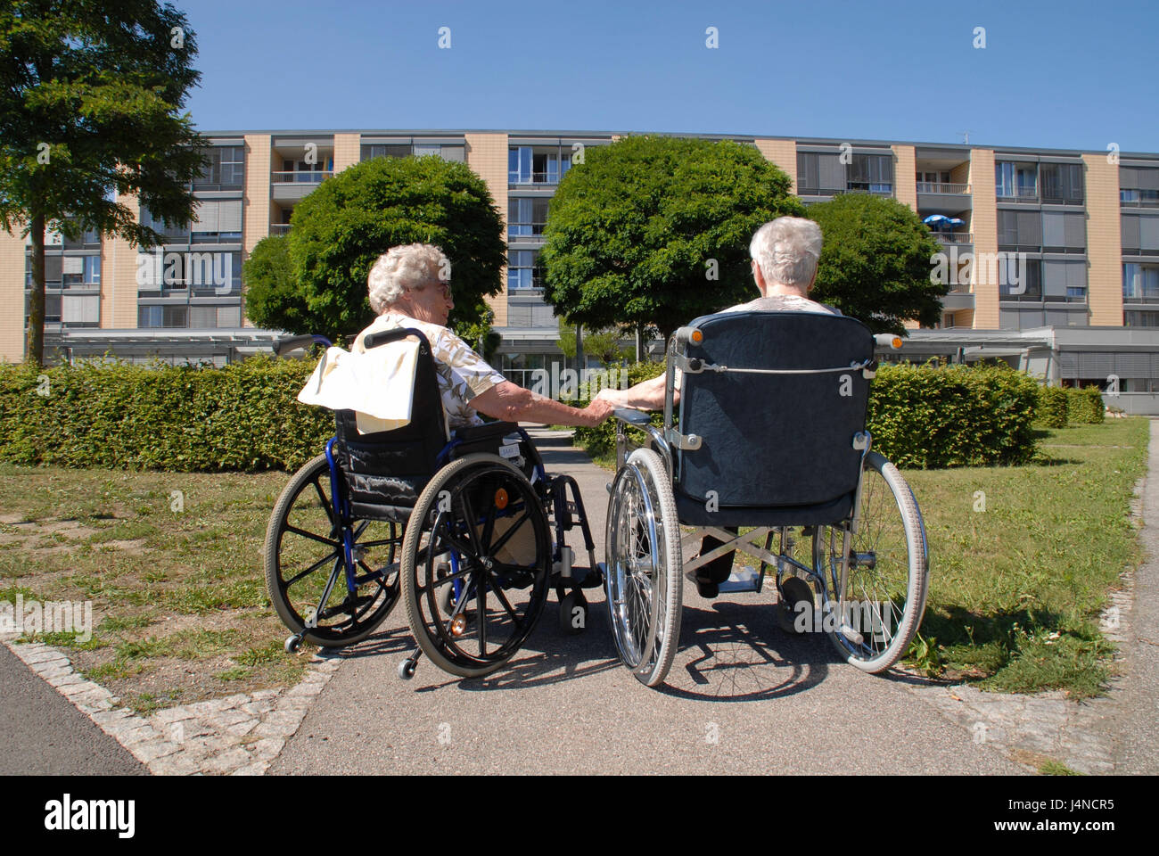 Seniors, invalid's wheel chair, garden, friendship, no model release, Stock Photo