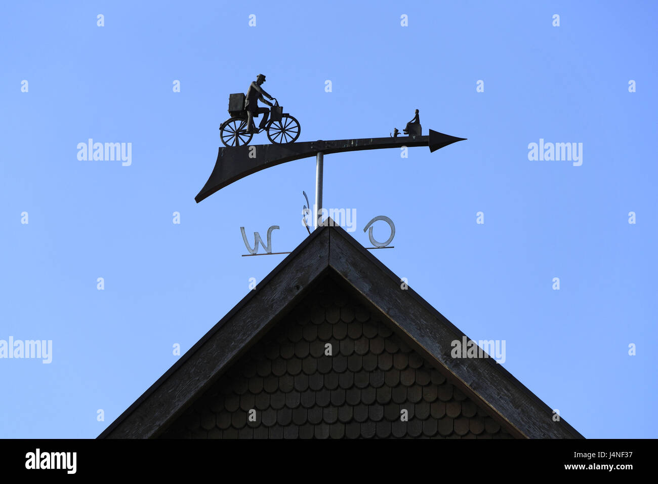 Wind direction indicator on a house roof, cyclist, arrow, Stock Photo