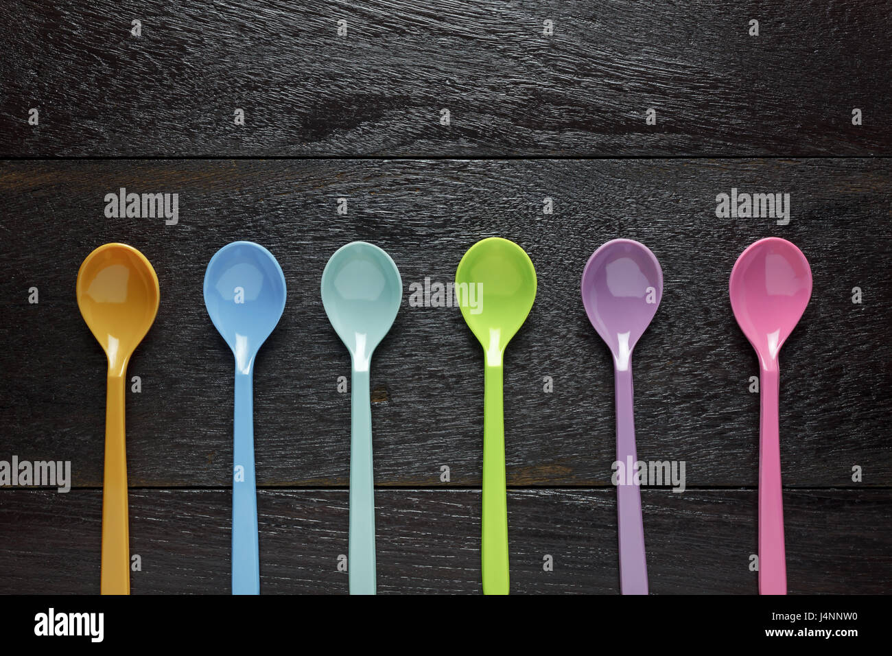 Top view colorful plastic spoon on wood table background with copy ...