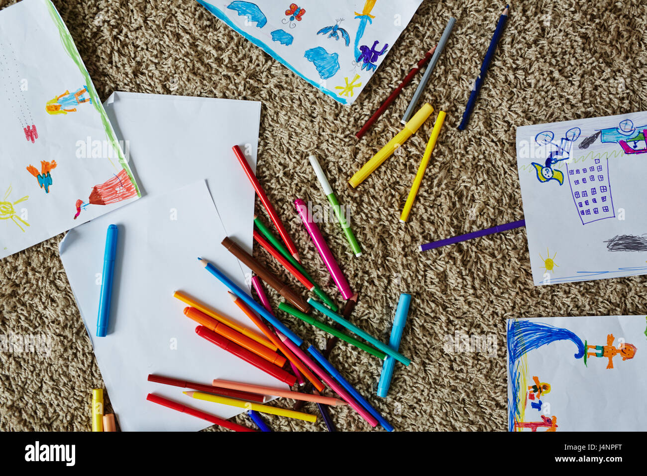 Set of crayons and highlighters, pictures of kids and empty papers on