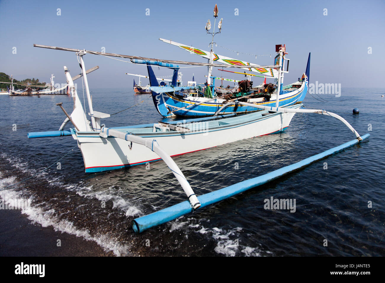 Beautiful ornate traditional boats on the Bali coast. Indonesian Jukung fishing boats freshly painted in pristine condition, beautiful coastal picture Stock Photo